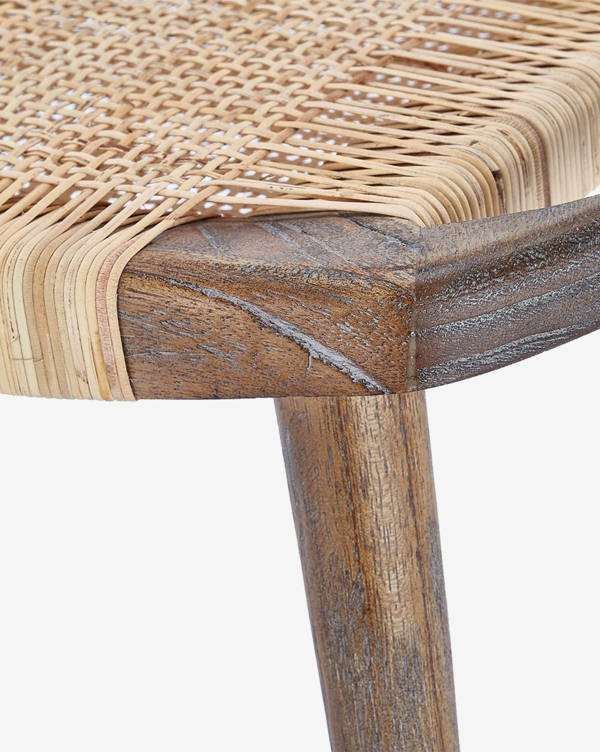 Certainly! Here’s your blended product description: Close-up of a Tallulah Stool by Villa & House, LLC, showing a corner and leg with handwoven cane seat in natural finish. The mahogany wood features a weathered, rustic look and distinctive grain patterns. McGee & Co.