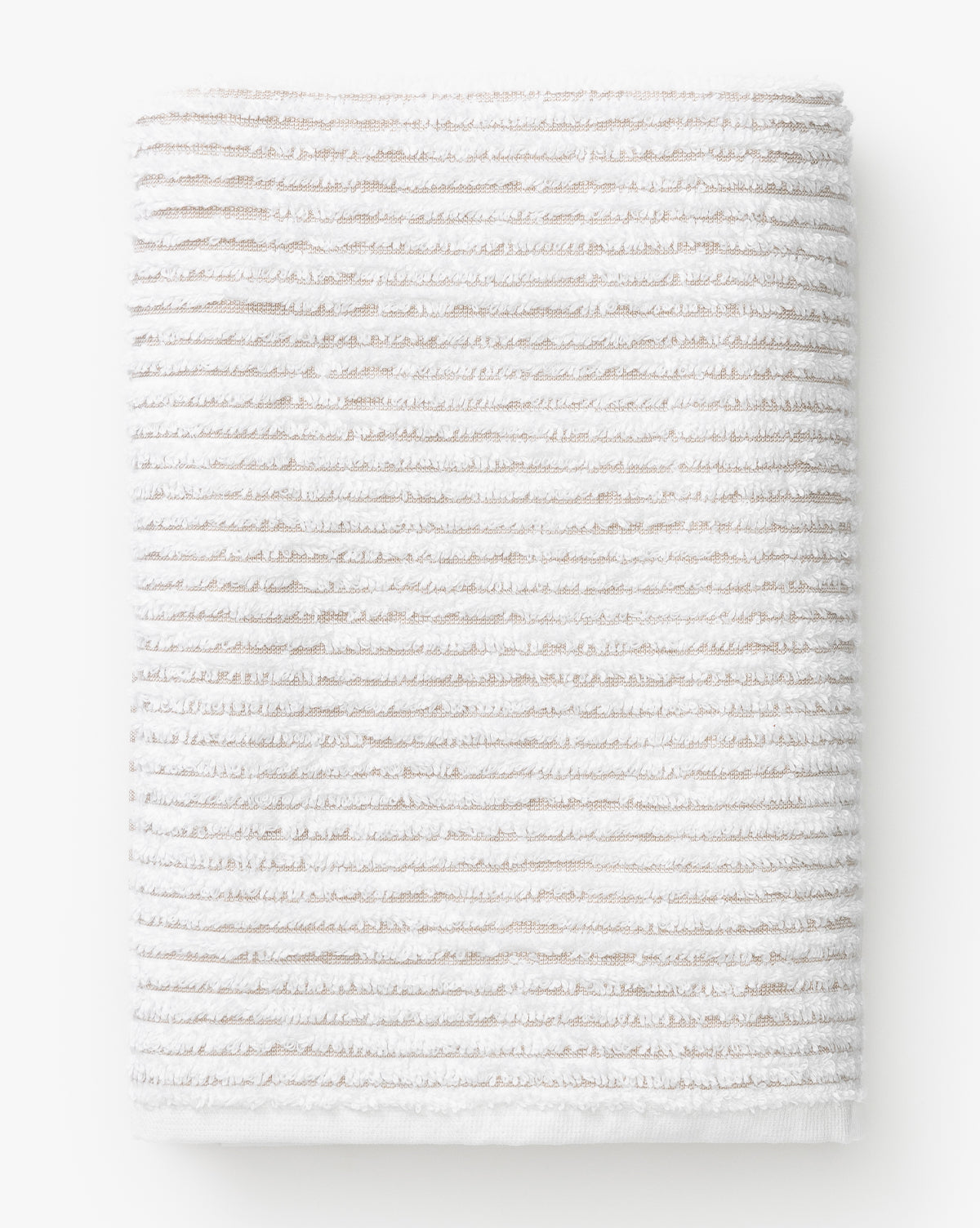 A folded towel from the Taupe Striped Bath Collection, featuring subtle horizontal beige stripes on a white background and a soft, textured look that hints at plush Aegean cotton for superior absorbency.