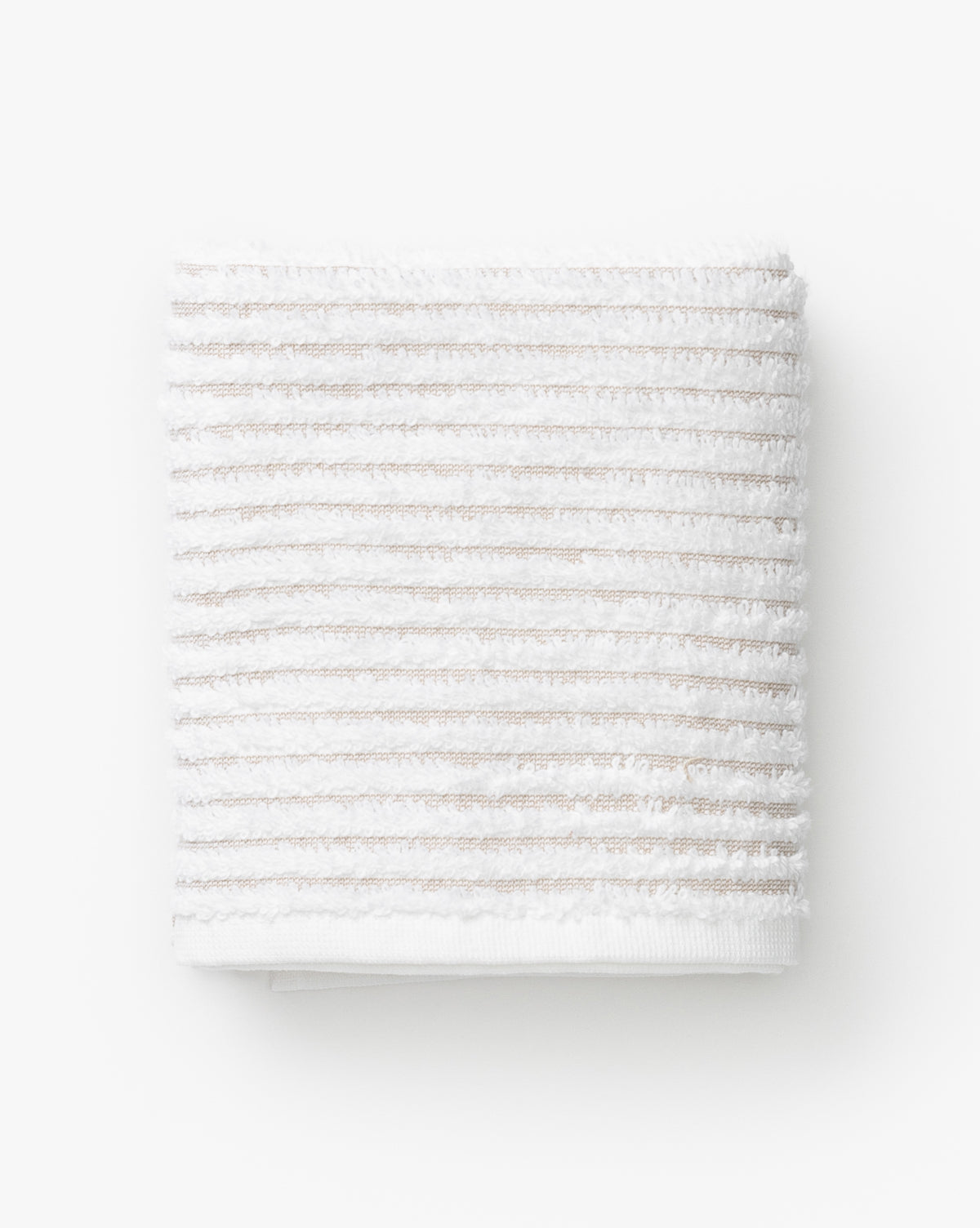 A neatly folded towel from the Taupe Striped Bath Collection, featuring white Aegean cotton and horizontal taupe stripes, placed on a plain white background.