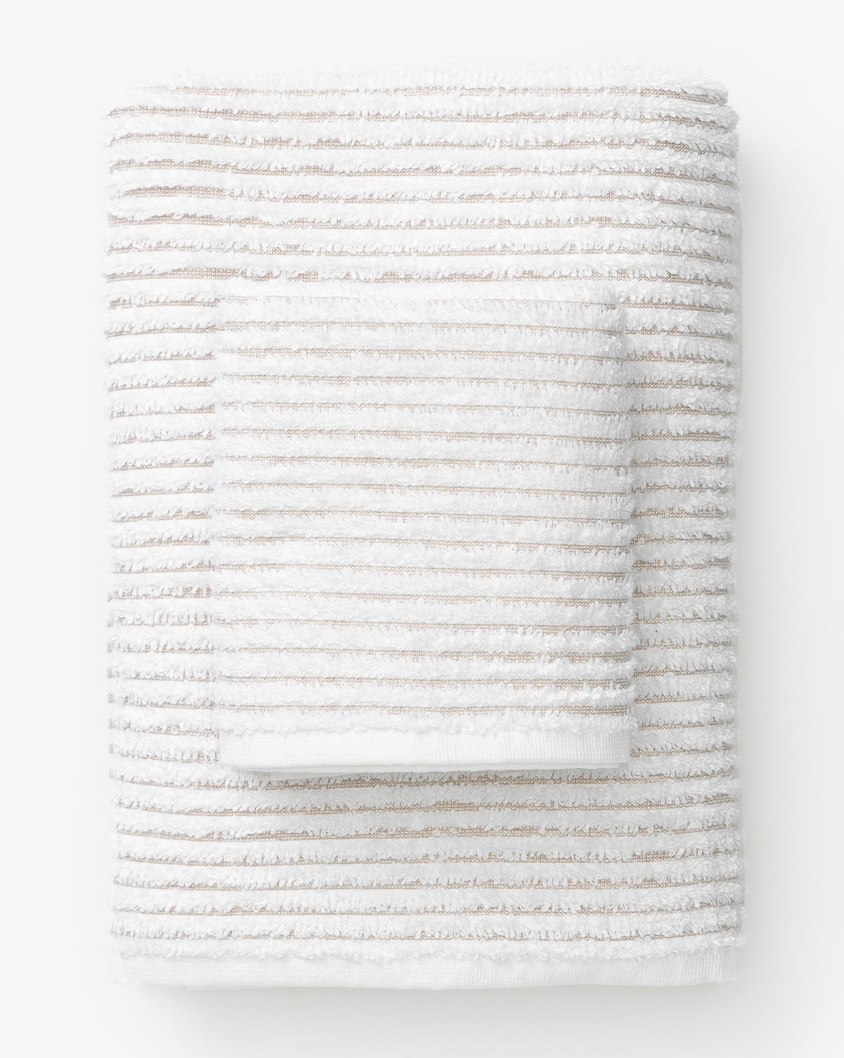 The Taupe Striped Bath Collection features a neatly folded bath towel with beige horizontal stripes and a matching smaller towel, both made from absorbent Aegean cotton, displayed on a white background.