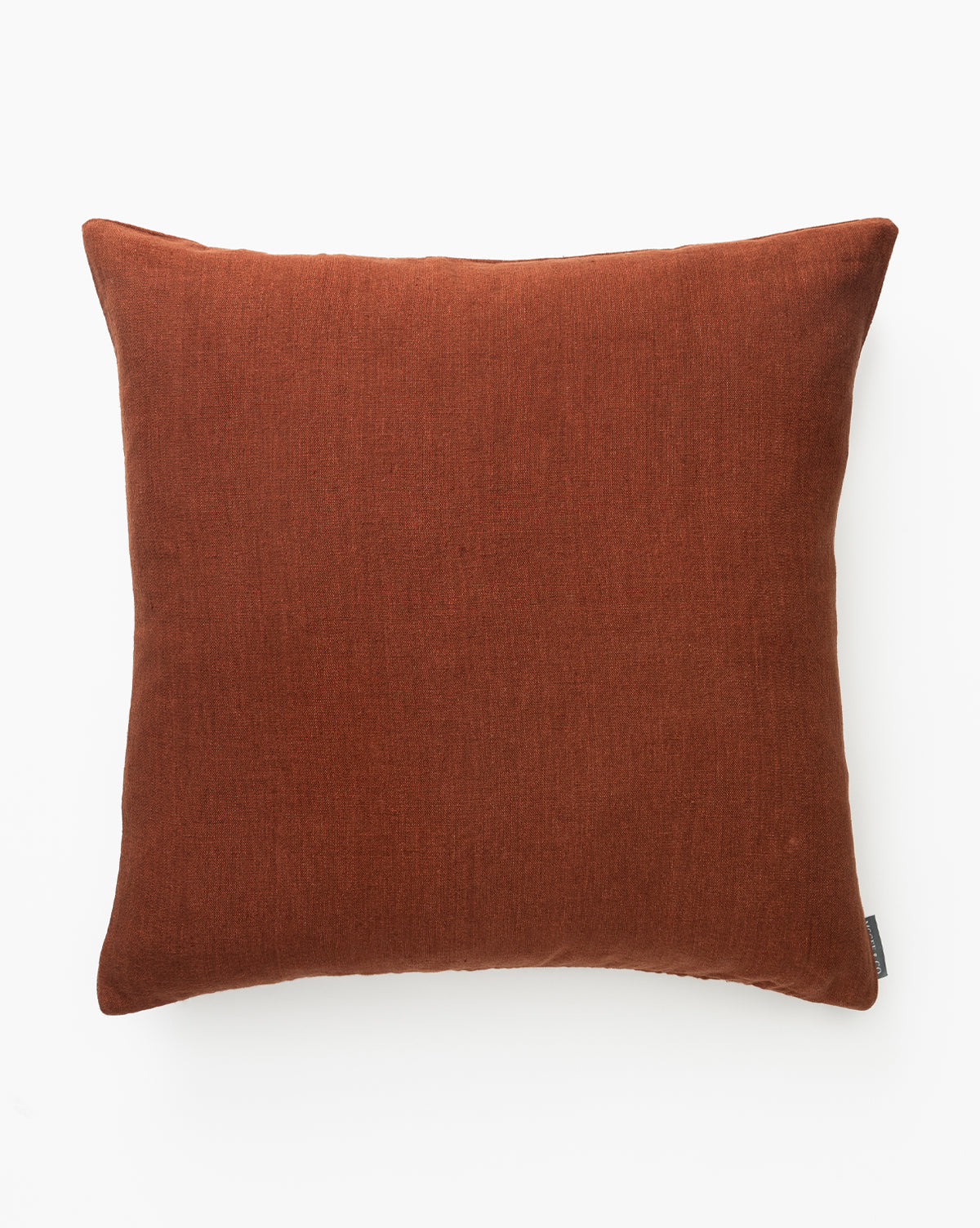 A rust-colored, square Teagan Pillow Cover with a soft, handwoven texture is shown against a plain white background, by McGee & Co.