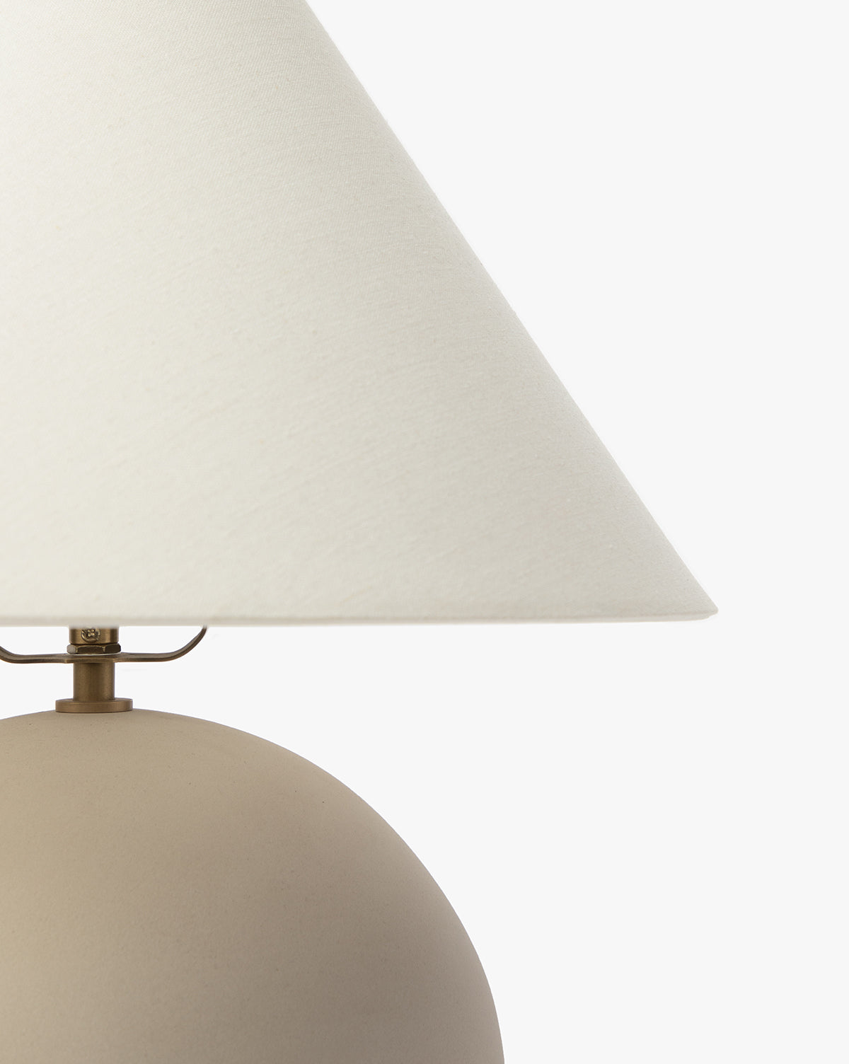 A close-up of the Tess Ceramic Table Lamp, featuring a matte beige rounded ceramic base and a white fabric shade, set against a plain white background, by McGee & Co.