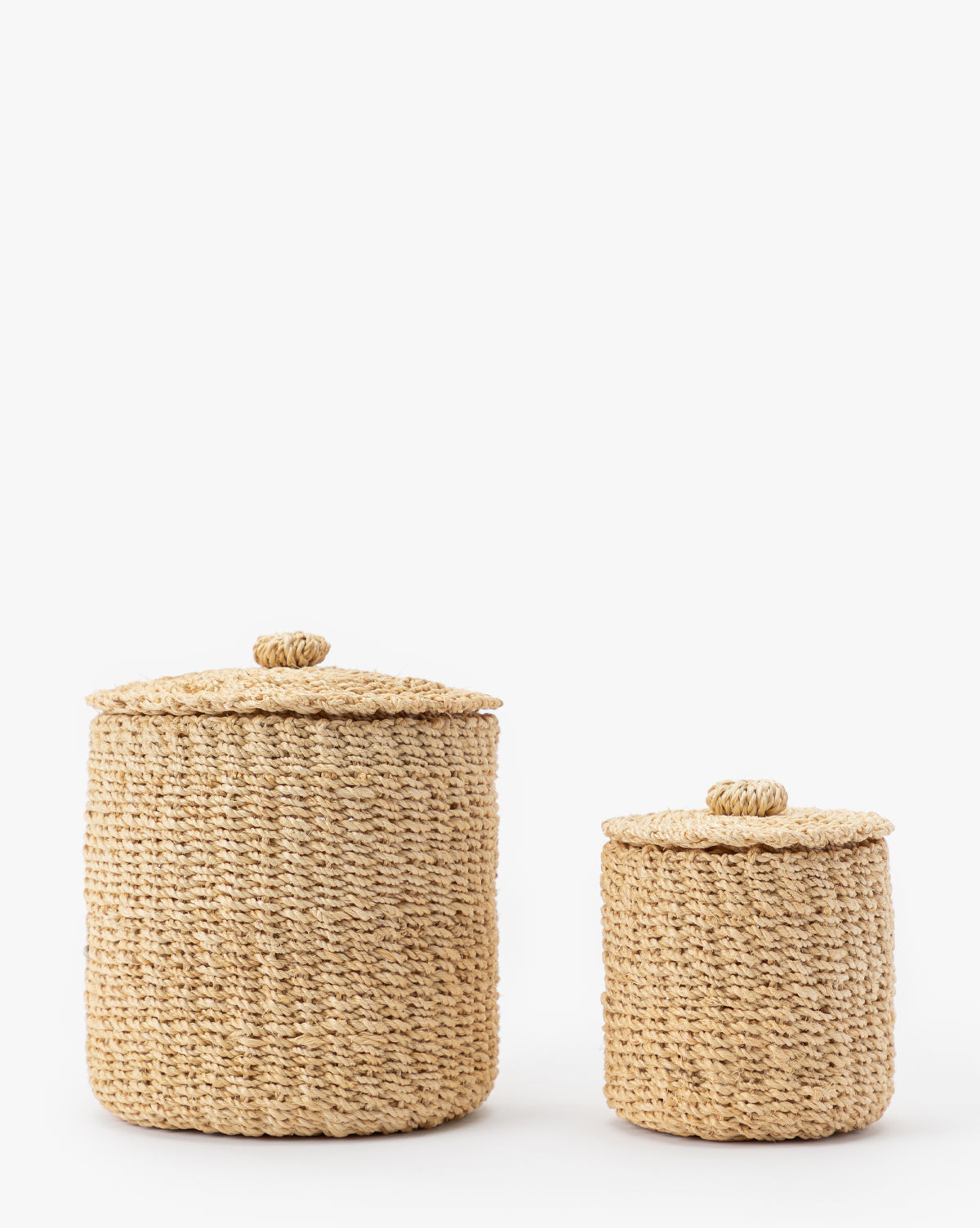 The Thalia Woven Canister set includes two round abaca baskets with lids in different sizes, perfect for stylish organic storage or adding natural charm to your bathroom counter decor.