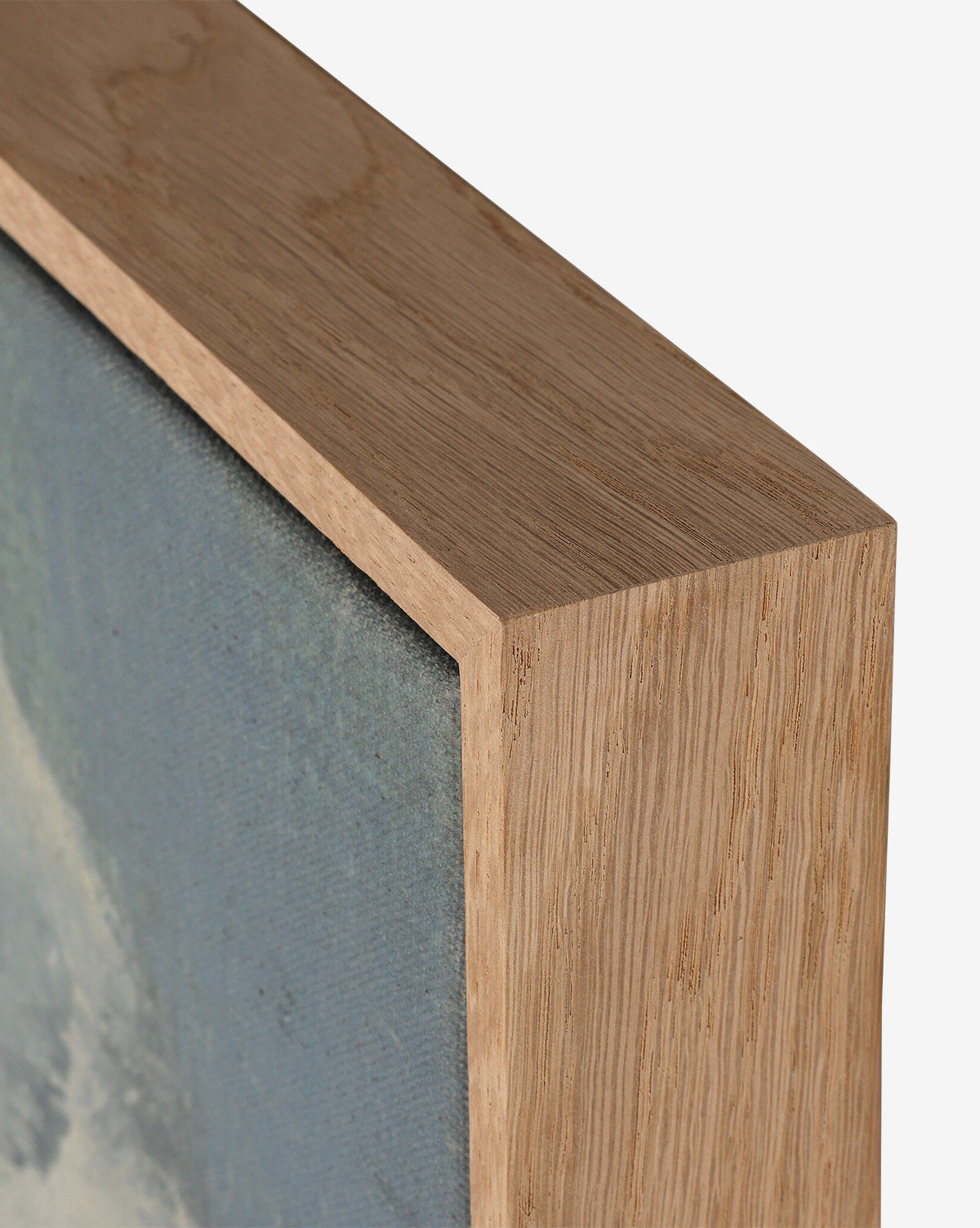 Close-up of the corner of a wooden picture frame with a natural finish, highlighting the texture of the wood and canvas surrounding The Long Way Home by Bethany Joseph, by McGee & Co.