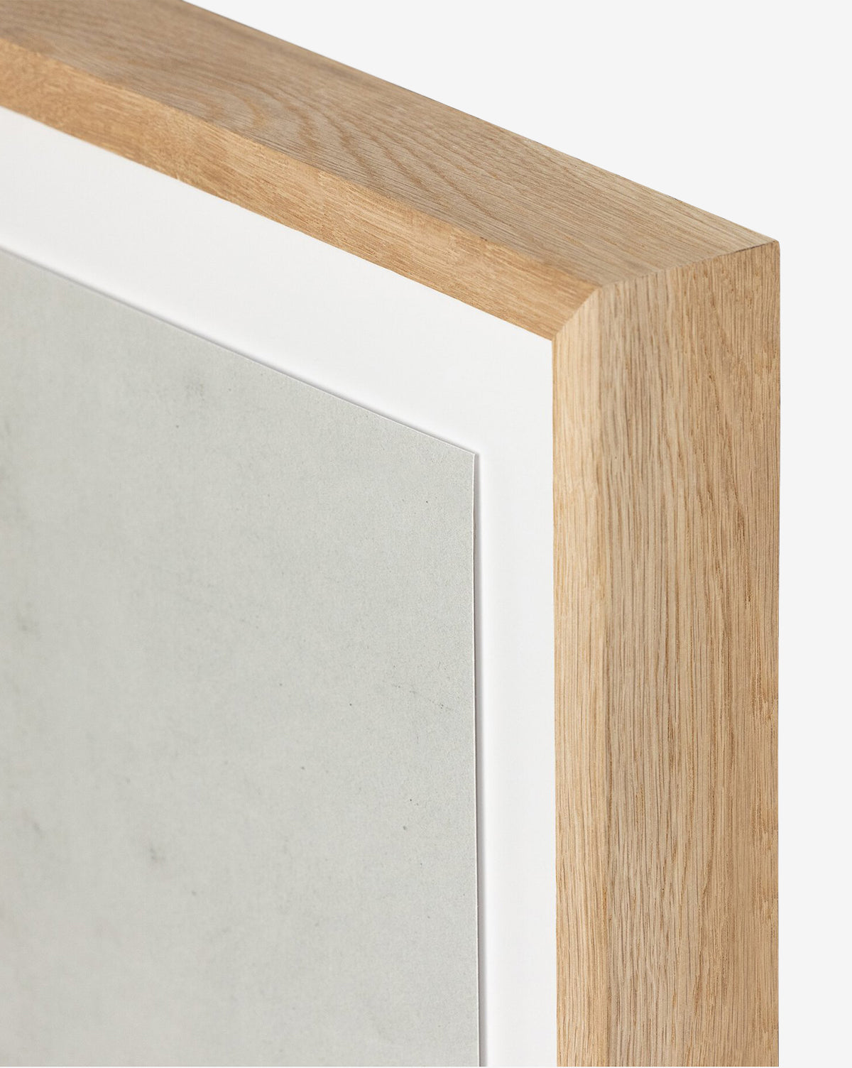 Close-up view of the corner of a white oak frame with a white mat board, featuring The Old Town by Dan Hobday—a minimalistic, light-colored artwork that’s ideal for showcasing dimensional wall art.