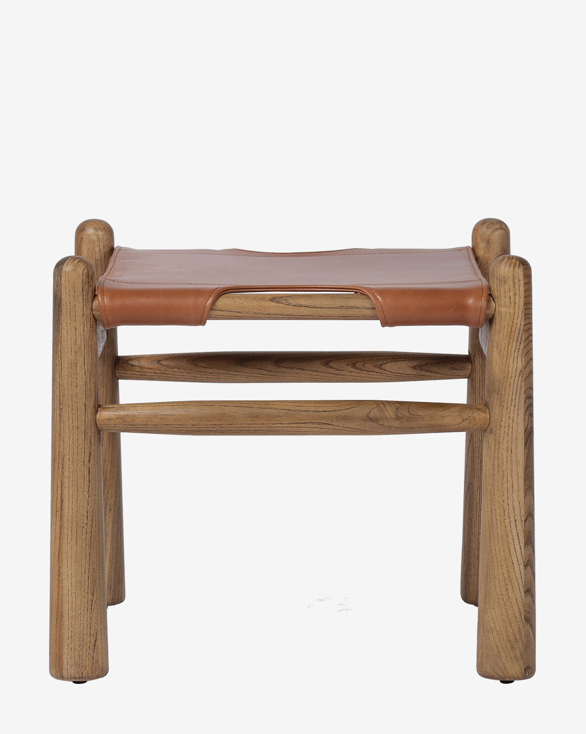 The Tierney Ottoman by Four Hands features a minimalist, rustic design with four sturdy legs, two horizontal support bars, and a top grain leather seat stretched over solid wood. McGee & Co.