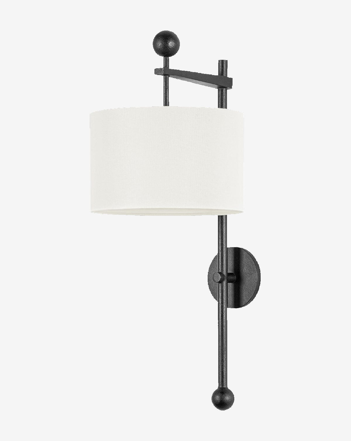 The Tisbury Sconce by Troy Lighting features a black forged iron frame with geometric accents and a cylindrical white fabric shade. Vertical and horizontal rods end in round finials, adding a sleek modern touch. McGee & Co.