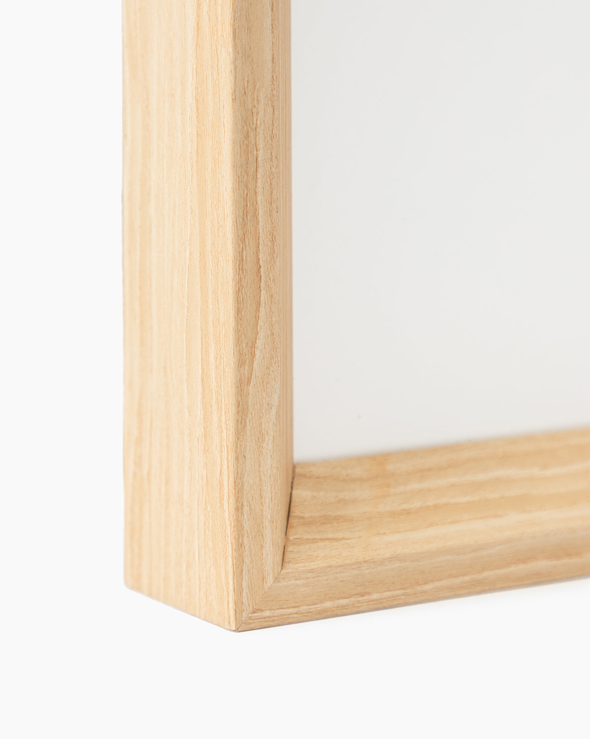 Close-up of the Town of Deia frame’s light natural woodgrain corner, highlighting its visible grain—ideal for displaying giclee print art, set on a plain white background.