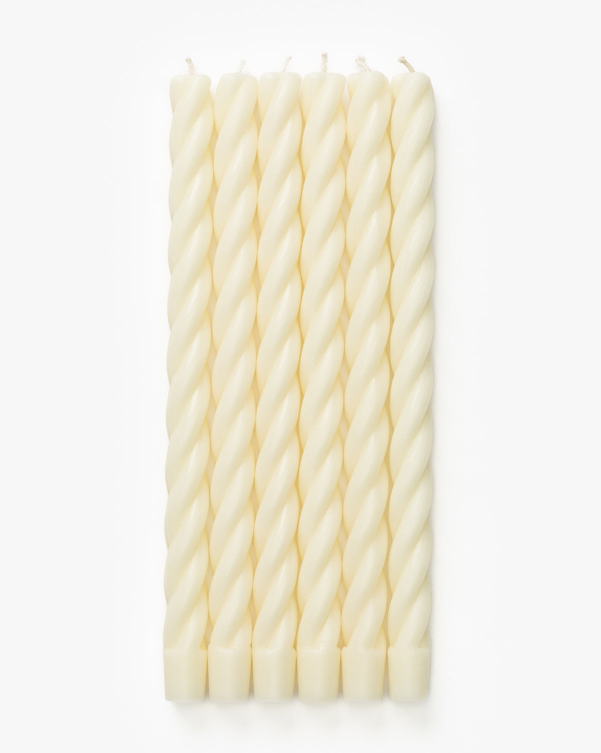 Six white Twisted Taper Candles are arranged in a neat row on a plain white background, perfect for adding elegant candlelight to your dining table, by McGee & Co.