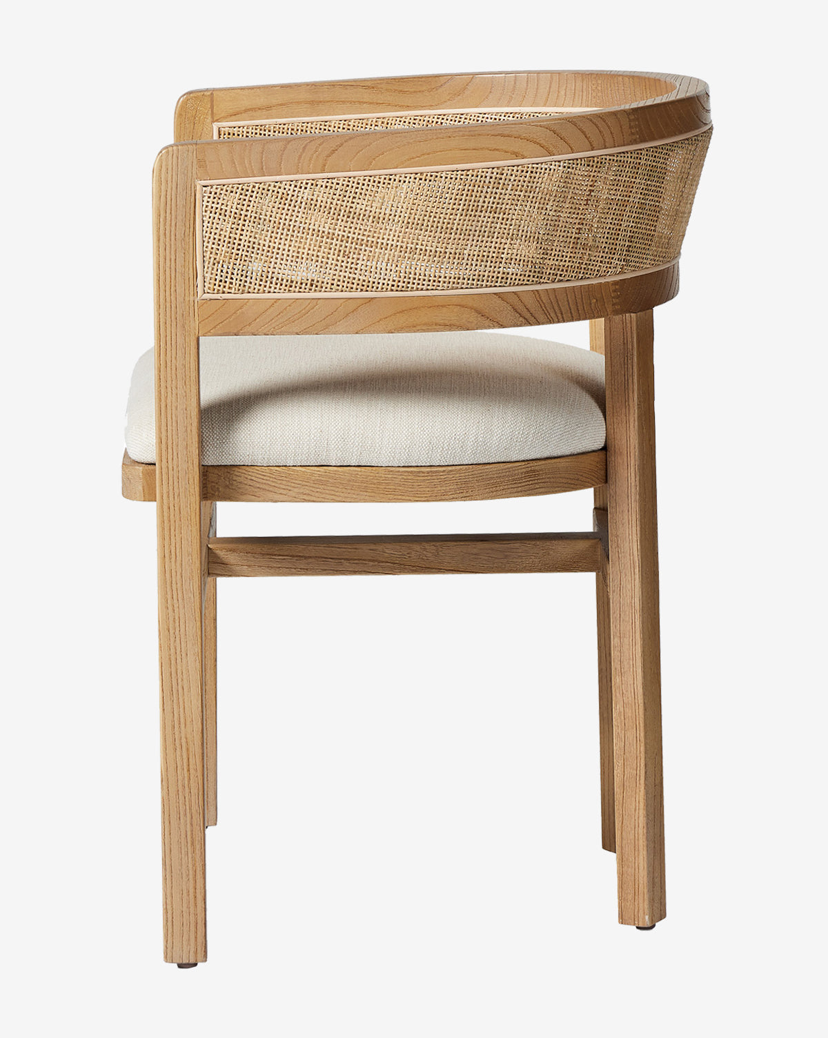 The Valissa Dining Armchair, shown from the side against a white background, features a curved wooden backrest, a woven cane seatback, and a light beige cushioned seat—ideal for modern interiors by McGee & Co.