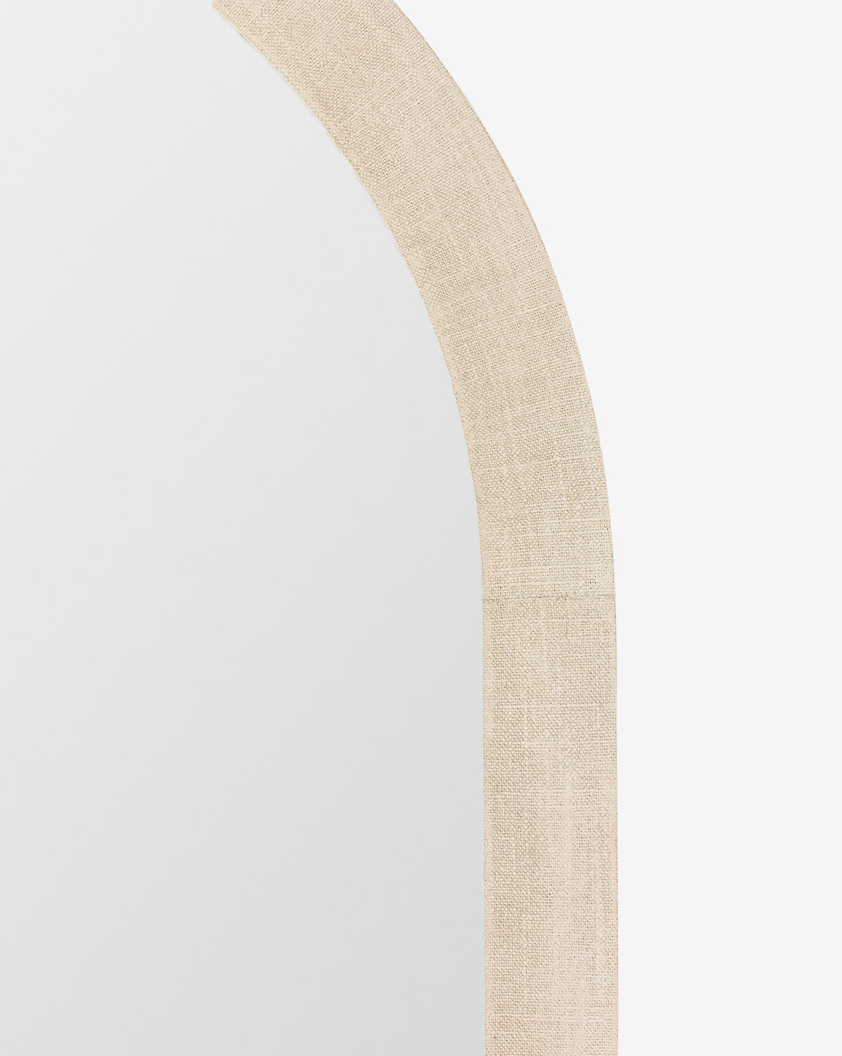 Close-up of the top right corner of the Vallie Arched Floor Mirror with an ivory linen frame, displayed against a plain white background, by McGee & Co.