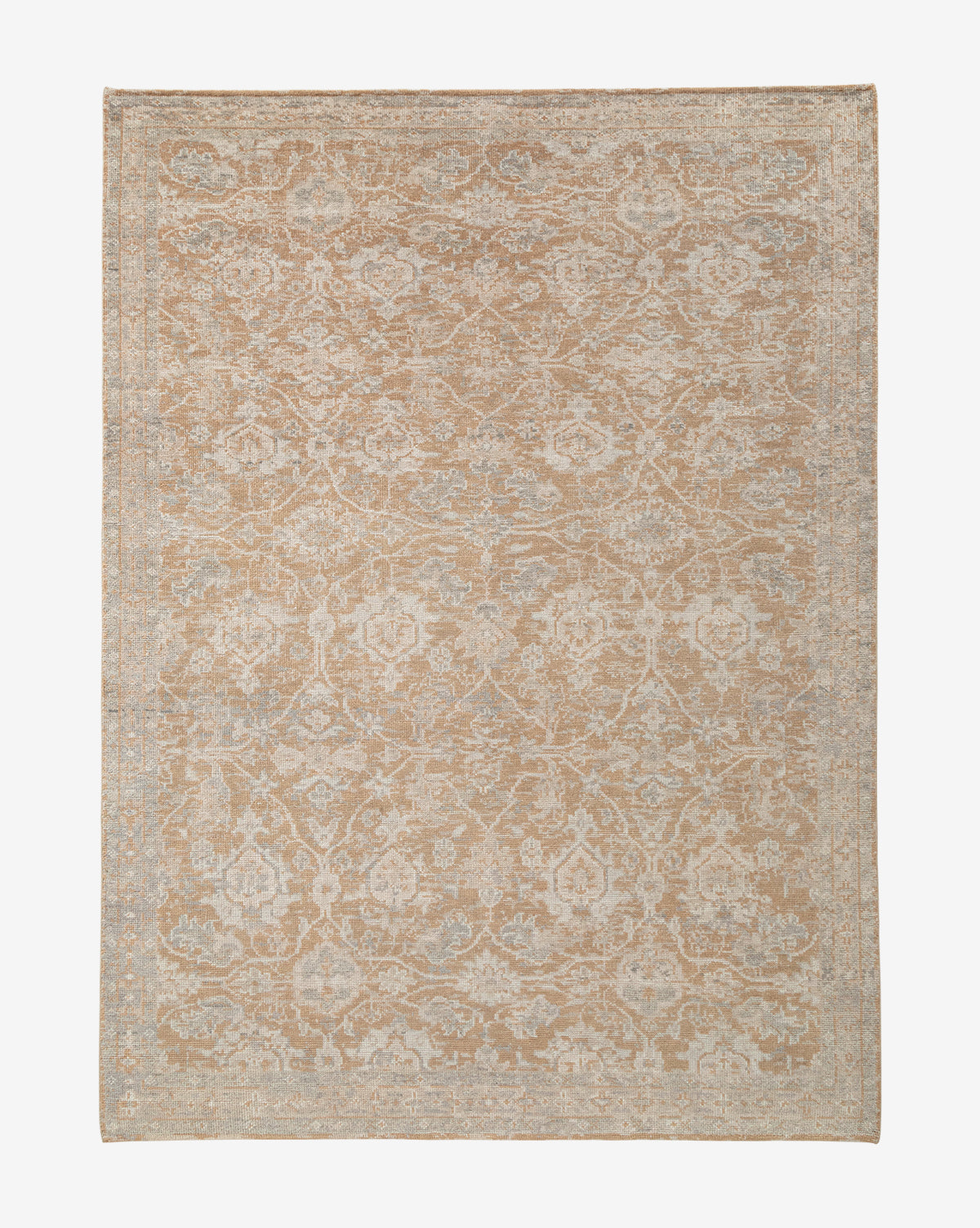 The Vanderwood Hand-Knotted Wool Rug showcases a vintage, distressed look with an intricate faded floral and vine pattern in beige and light blue, darker edges, and a symmetrical design that enhances its timeless, traditional charm, by McGee & Co.