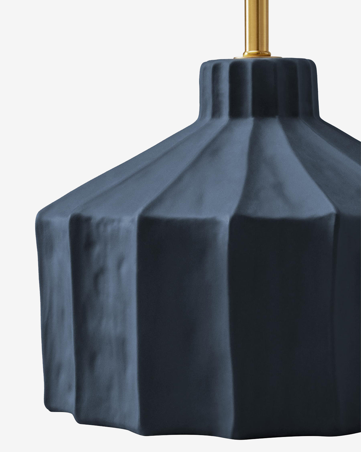 A close-up of the Veneto Table Lamp shows its dark blue, geometric matte-finished shade and gold top fixture against a white background—an elegant nod to classic traditional style, by McGee & Co.