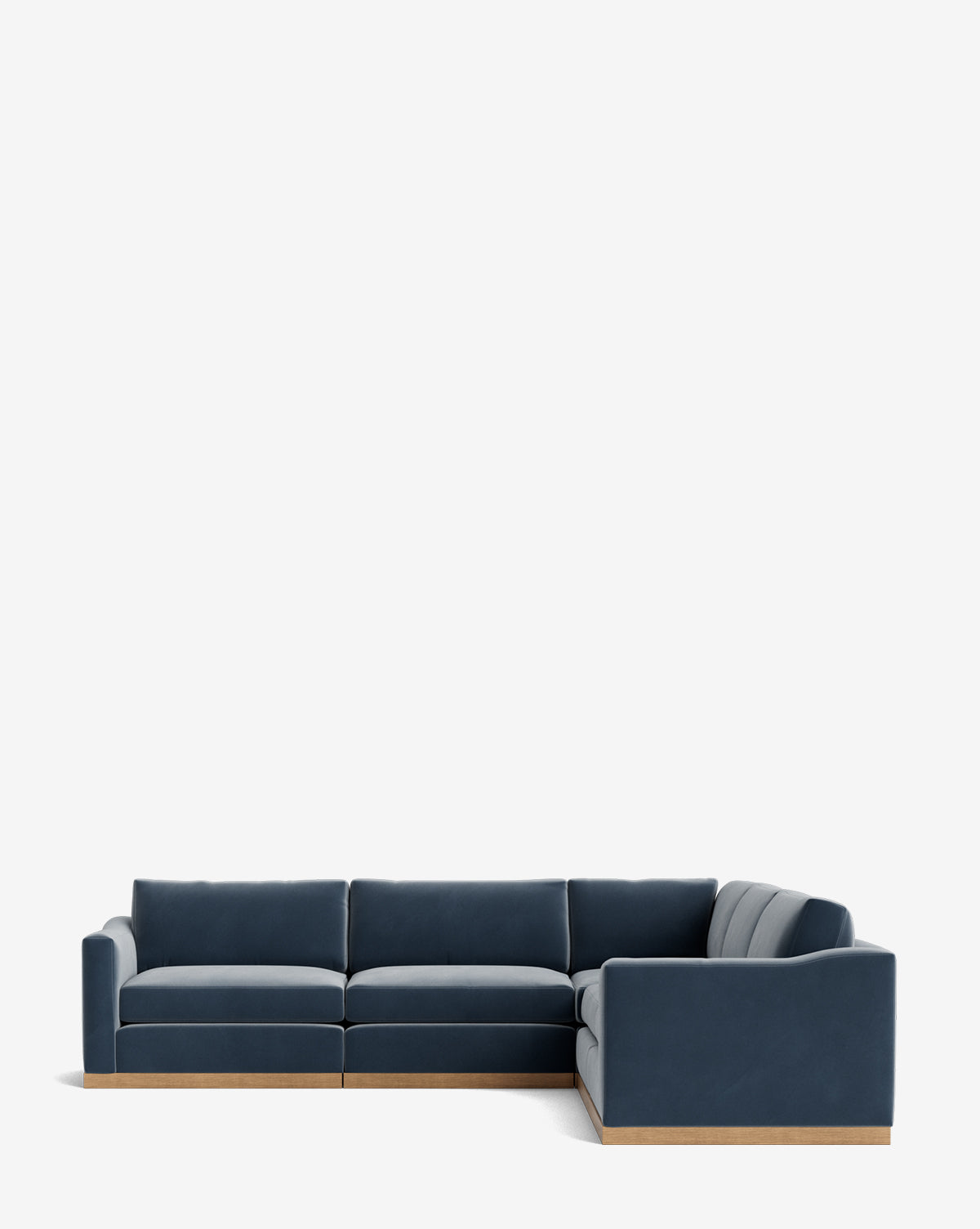 The Vernon Modular L Sectional 117.5 features deep blue velvet upholstery and a light wooden base, showcased against a plain white background, by McGee & Co.