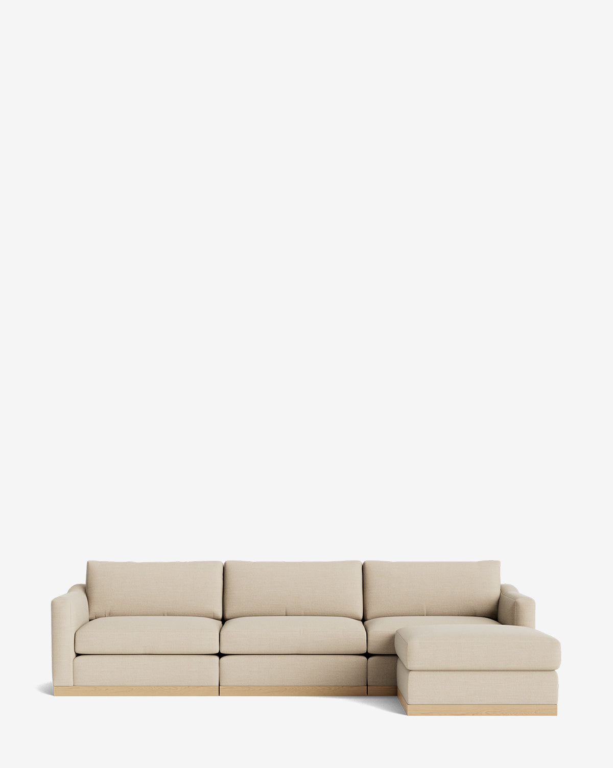 The Vernon Modular Sofa with Ottoman 121 is a modern beige sectional featuring clean lines, a right chaise lounge, a low light wood base, and customizable fabric—ideal for any contemporary space, by McGee & Co.