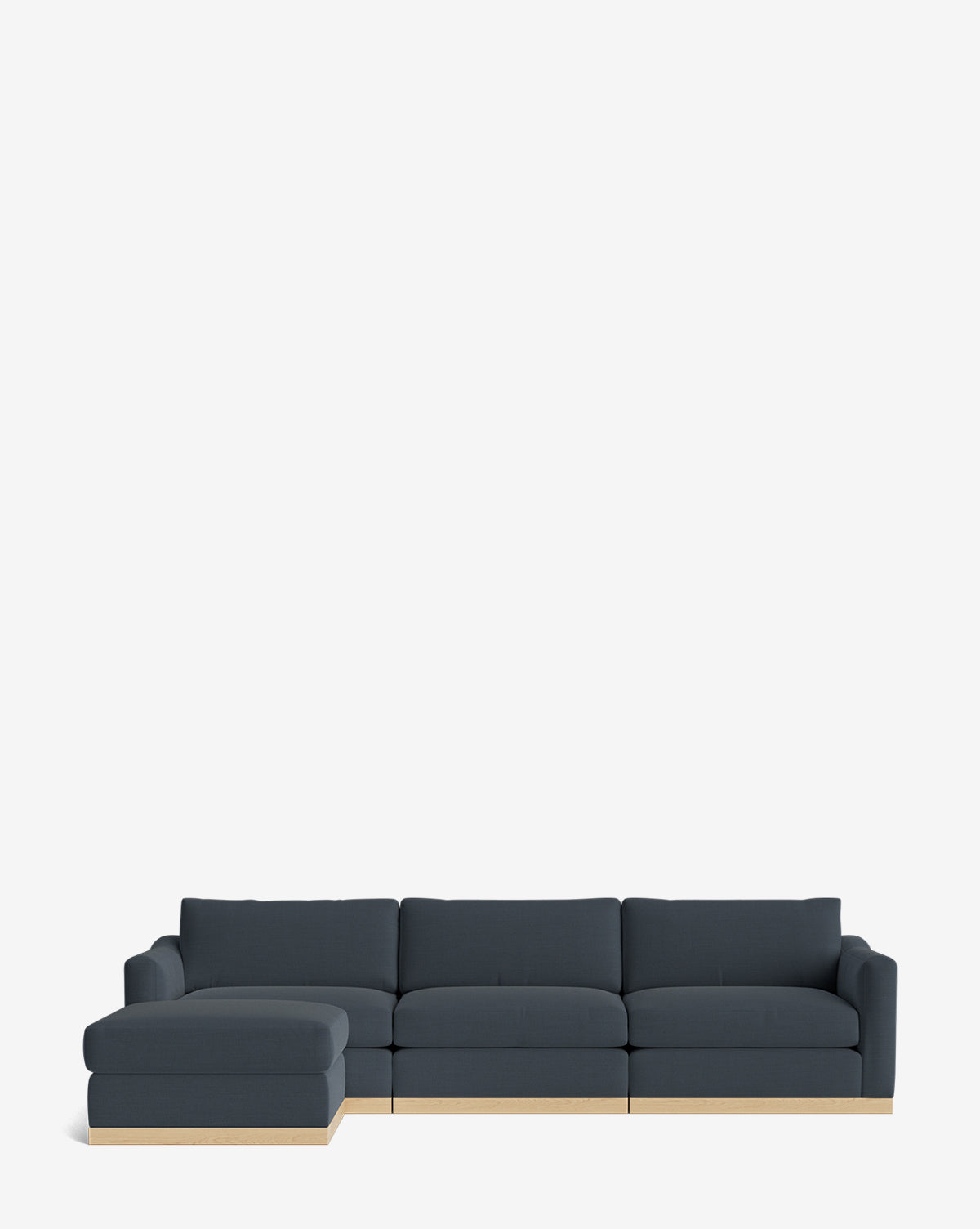 The Vernon Modular Sofa with Ottoman 121 is a modern dark grey customizable fabric sectional with a left-facing chaise, light wood base, and ottoman, shown against a plain white background by McGee & Co.