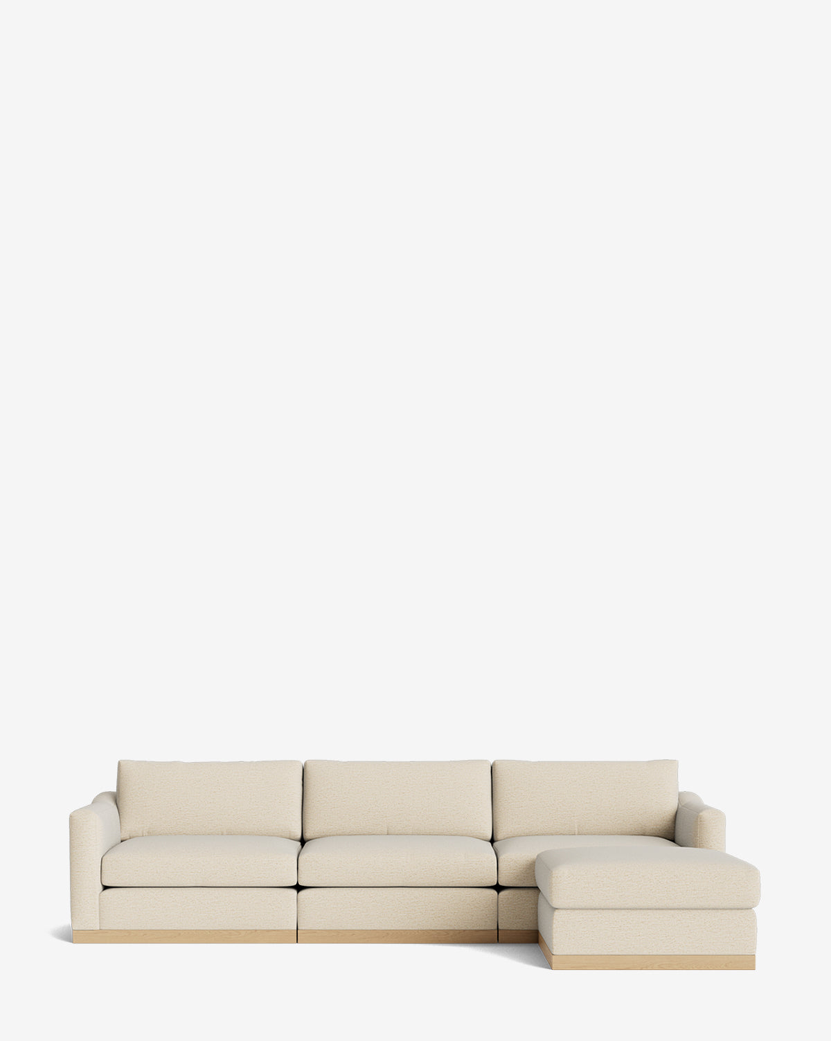 The Vernon Modular Sofa with Ottoman 121 in beige features four seat cushions, a right-side chaise lounge, simple lines, and a wooden base, offering customizable fabric options against a plain white background by McGee & Co.