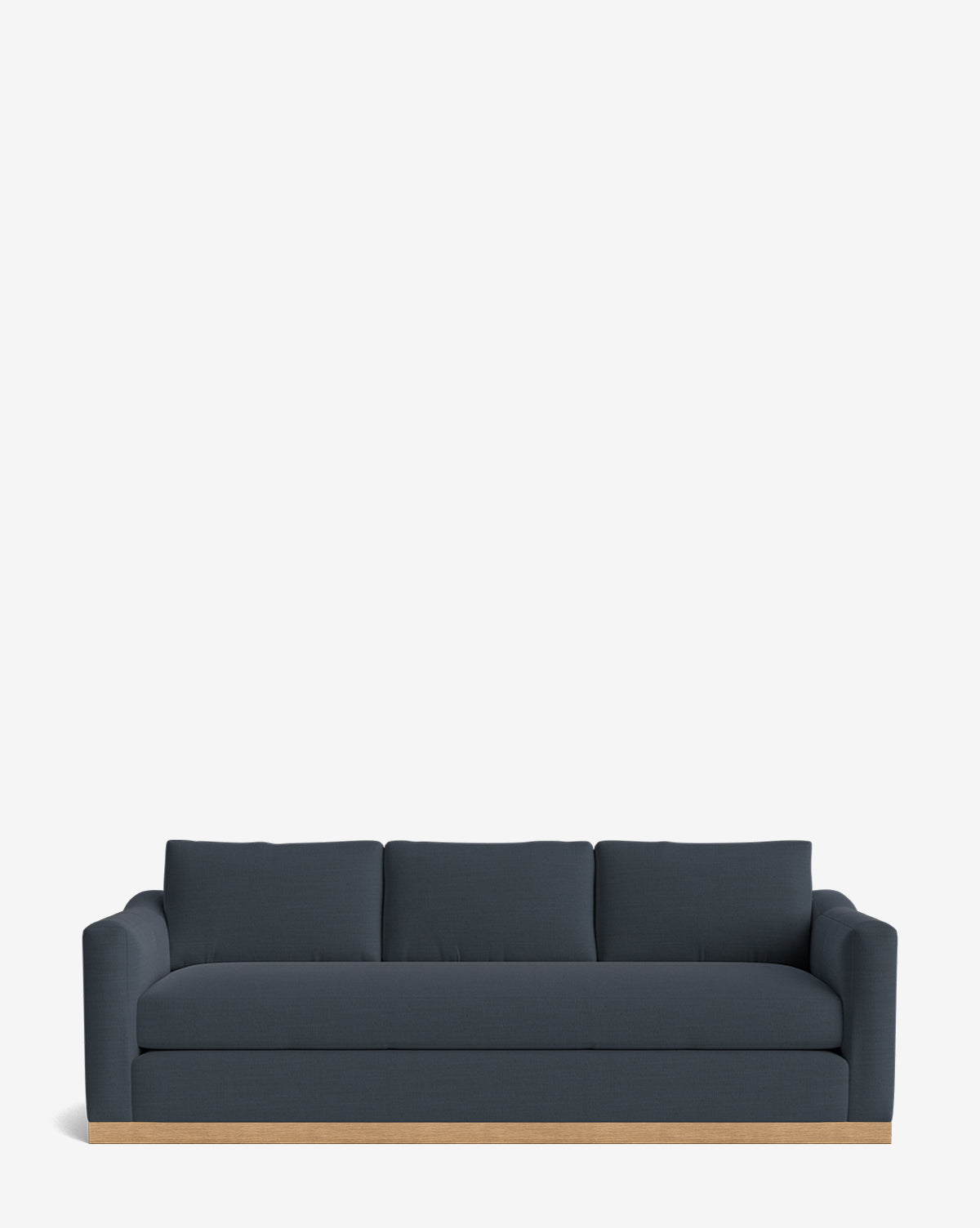 A Vernon Sofa 92 in dark blue velvet with low arms and back cushions rests on a light alder wood frame, set against a plain white background by McGee & Co.