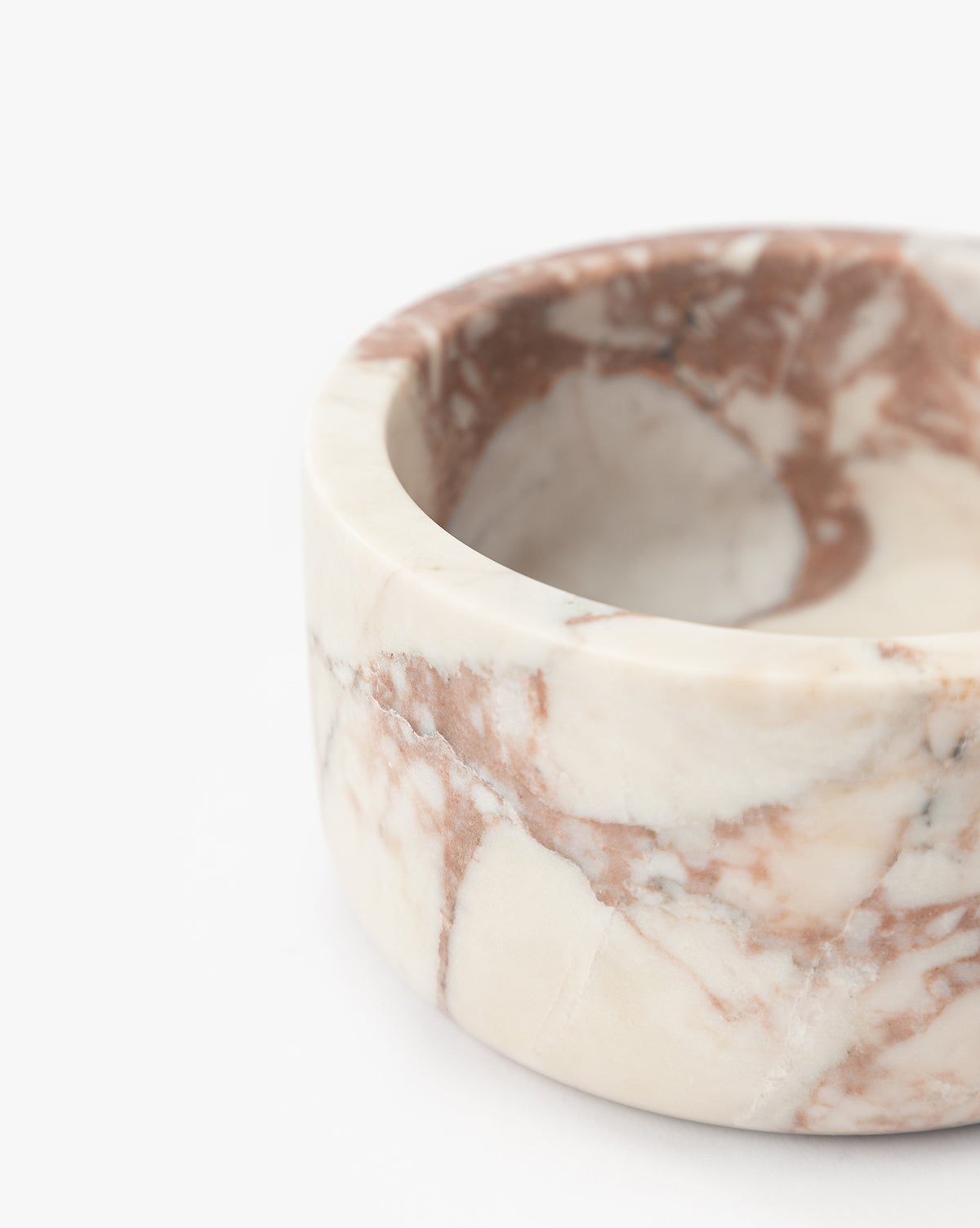 A close-up of the Verona Marble Bowl, a round piece with a matte finish and cream and brown veining, set against a white background, by McGee & Co.