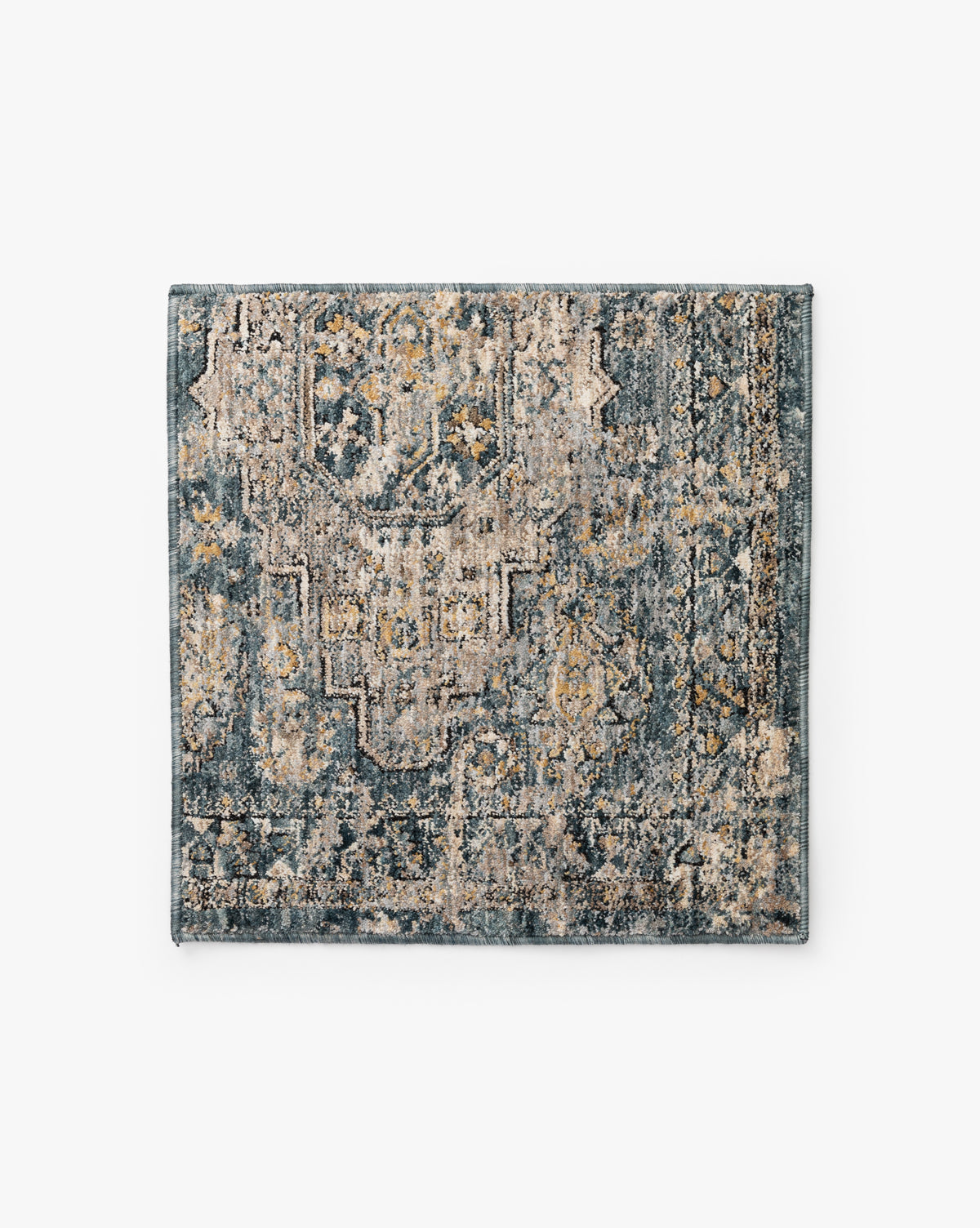 The Vesima Rug Swatch features a square sample of area rug with a distressed, vintage-inspired pattern in blue, beige, and gold, highlighted by intricate geometric and ornate designs by McGee & Co.