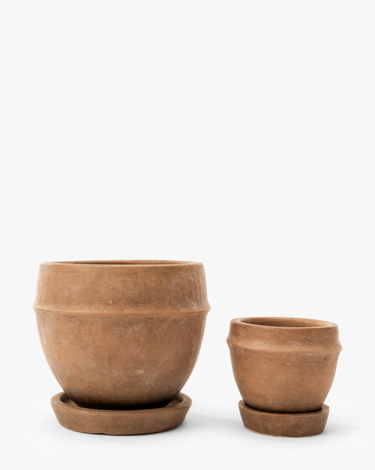 Two Vichy Terracotta Planters by Terra Cotta Art Works, Inc.—one large and one small—feature a simple, rustic design with matching saucers, perfect for indoor or outdoor plants. Shown side by side on a white background. McGee & Co.