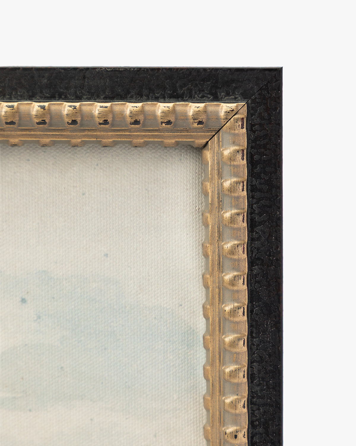 Close-up of the top-right corner of the View of St Catherines Hill Near Guildford by Charles Claude Pyne, featuring a textured black outer edge, decorative gold inner edge, and part of a canvas with light, subtle colors by McGee & Co.