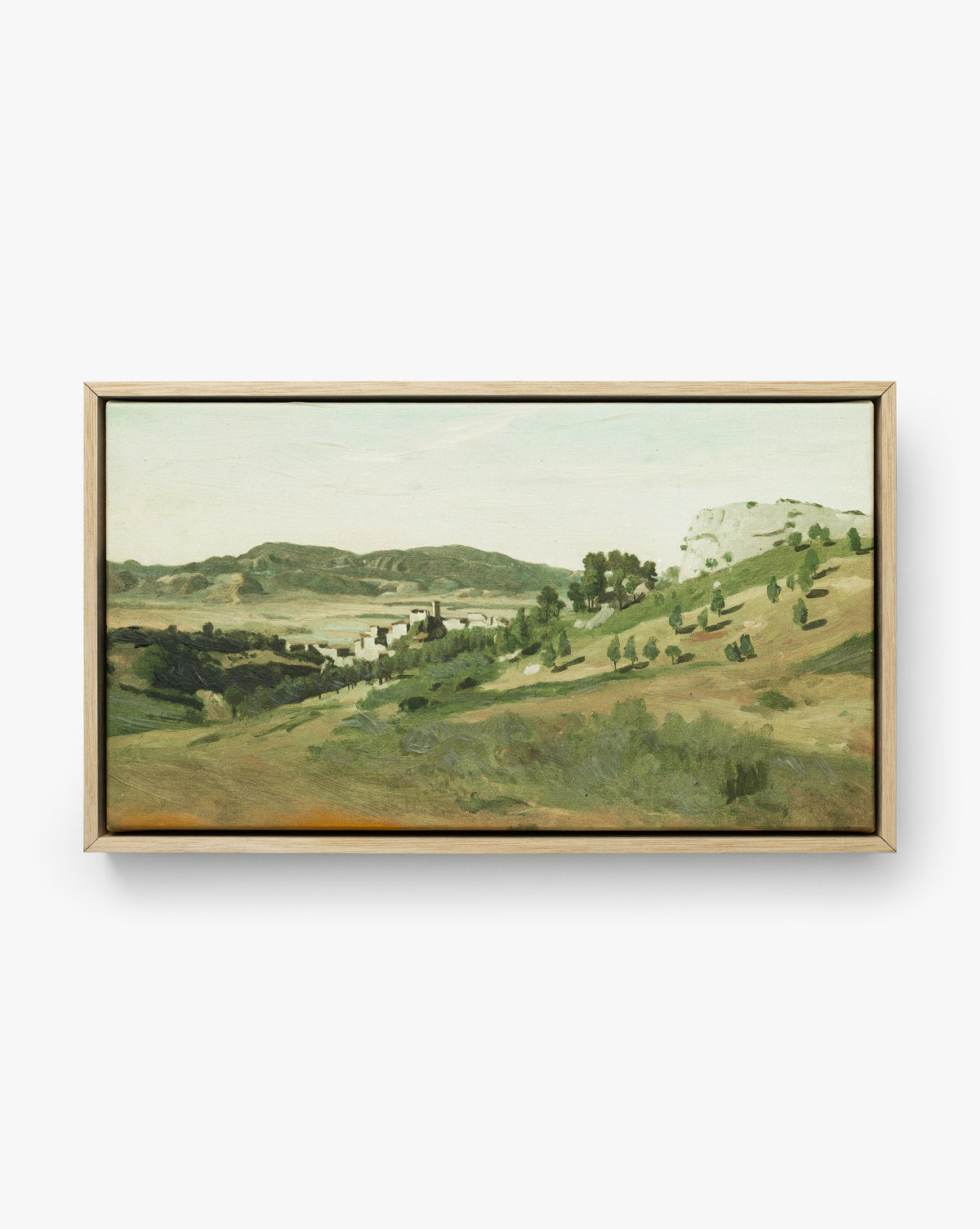 View of the Town is a landscape canvas in an oak frame, depicting rolling hills, scattered trees, and a distant village under a pale sky in earthy green and brown tones by McGee & Co.