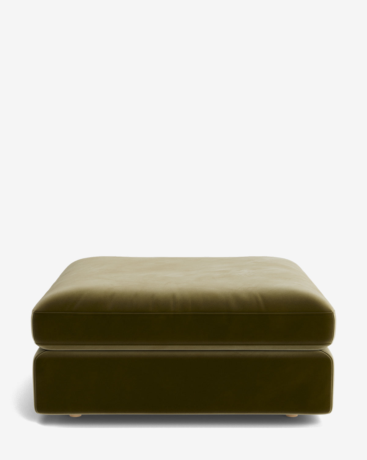 The Vivienne Modular Ottoman is large, square, and olive green with plush velvet upholstery, a thick cushion, and short round legs. It’s shown against a plain white background by McGee & Co.