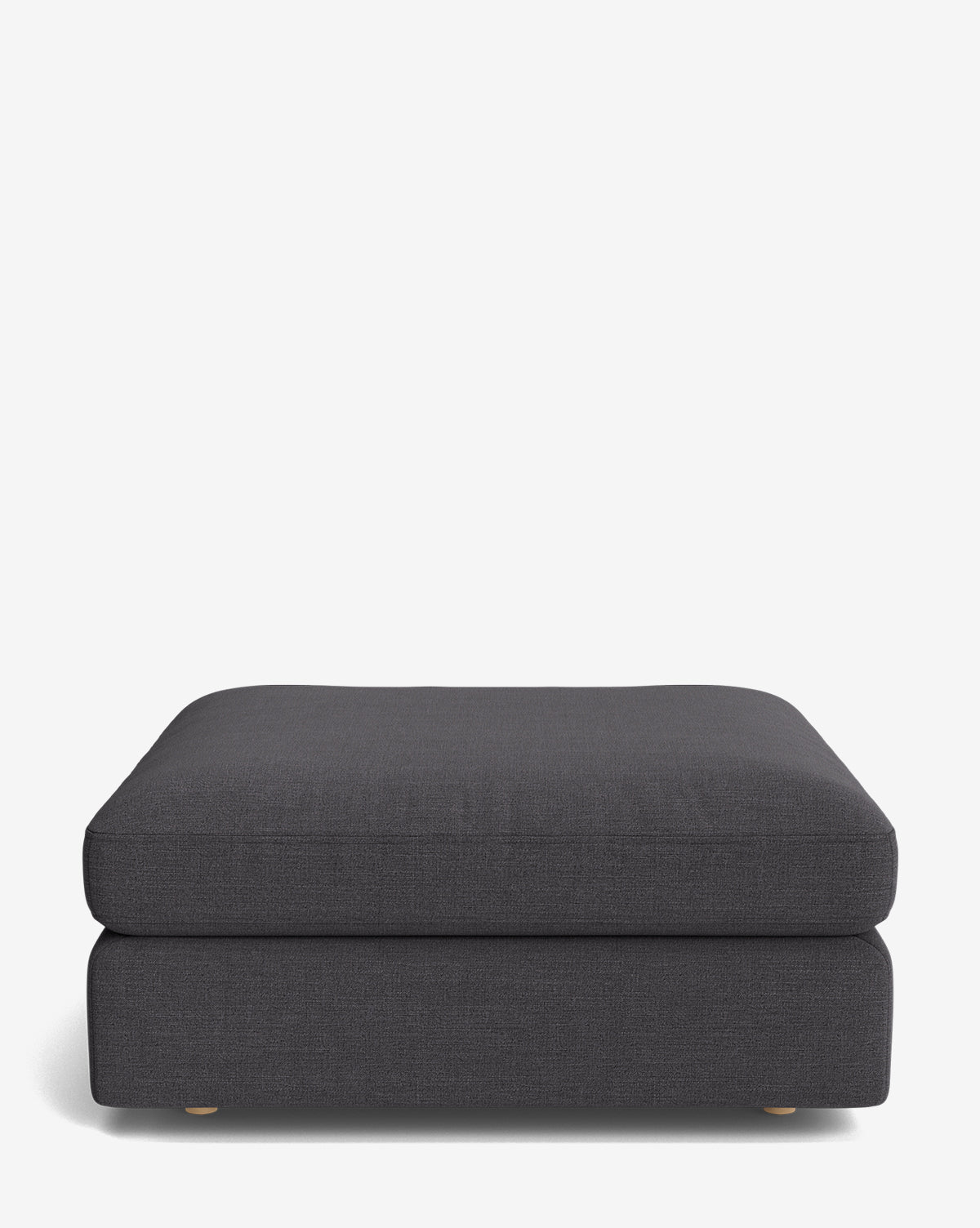 The Vivienne Modular Ottoman is a handmade, minimalist rectangular piece in dark gray with a plush cushion and low wooden feet, showcased against a plain white background by McGee & Co.
