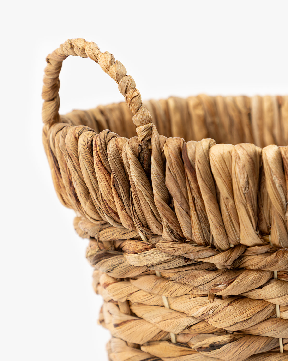 Close-up of Water Hyacinth Baskets with Handles (Set of 2), showcasing natural brown fibers and textured handwoven design against a plain white background—ideal for decorative storage, by McGee & Co.
