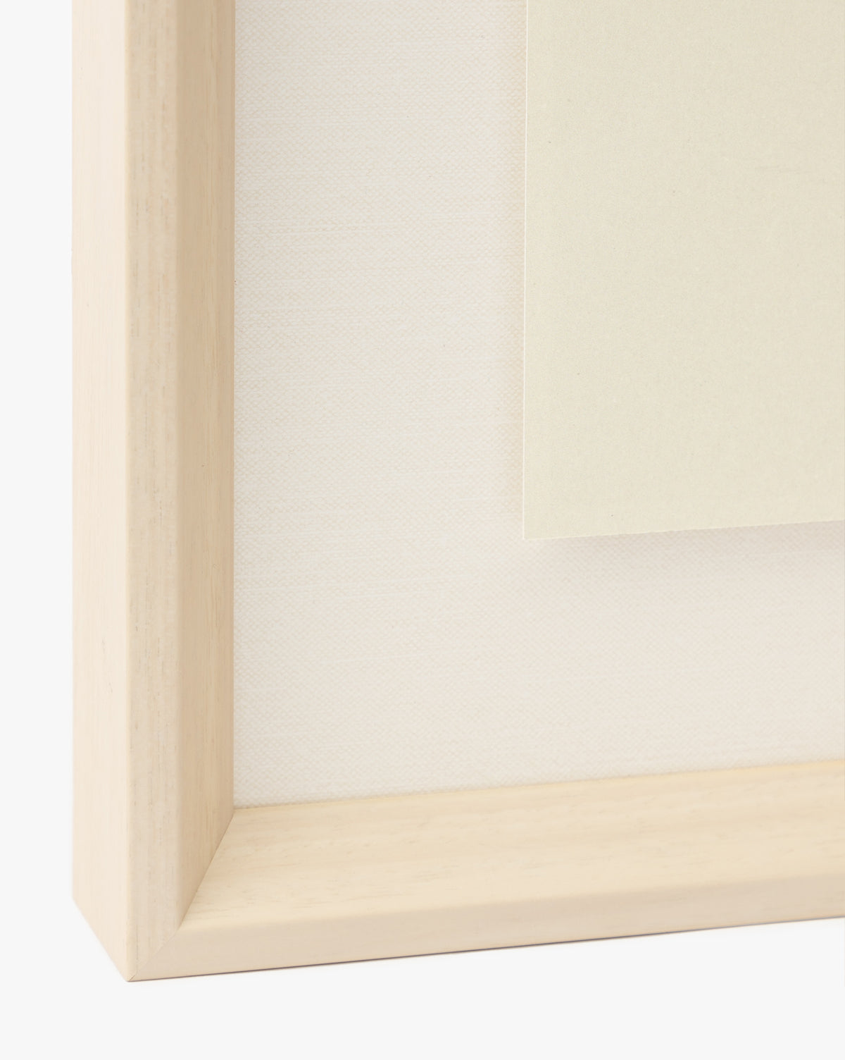 Close-up of a light wooden frame with a white textured background and off-white paper, perfect for displaying the Watermelon Collage giclee print in a childrens room, by McGee & Co.