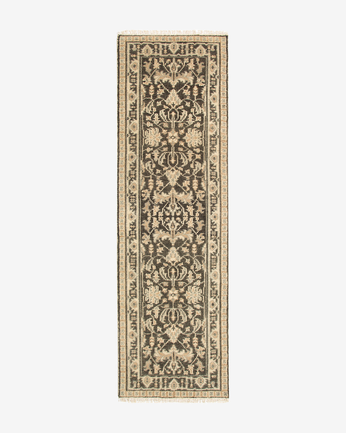 The Wayland Hand-Knotted Wool Rug is a rectangular narrow runner featuring an intricate black and beige floral and vine pattern, decorative border, and fringed ends—an artisan wool rug of exquisite craftsmanship, by McGee & Co.