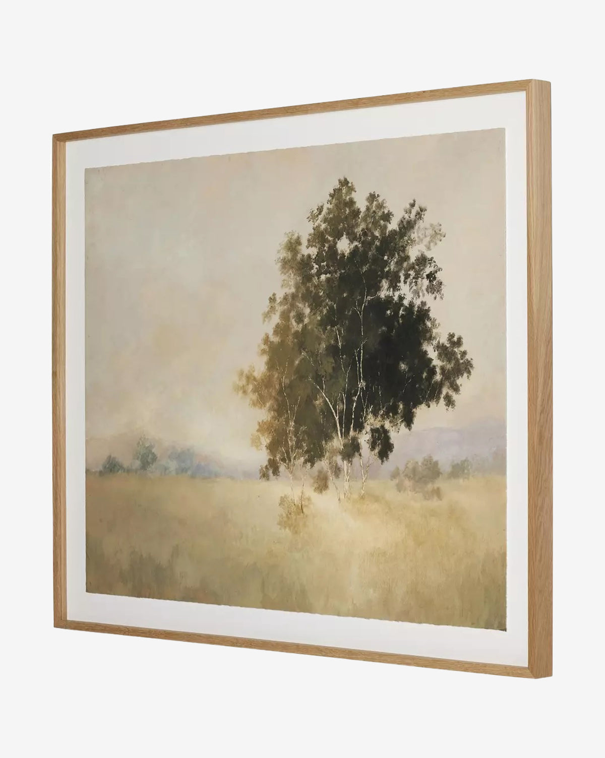 We Woke To A Dream by Aileen Fitzgerald features a solitary tree in a misty field with muted colors and a hazy sky, creating a serene atmosphere. Displayed in an elegant white oak frame for timeless appeal, by McGee & Co.