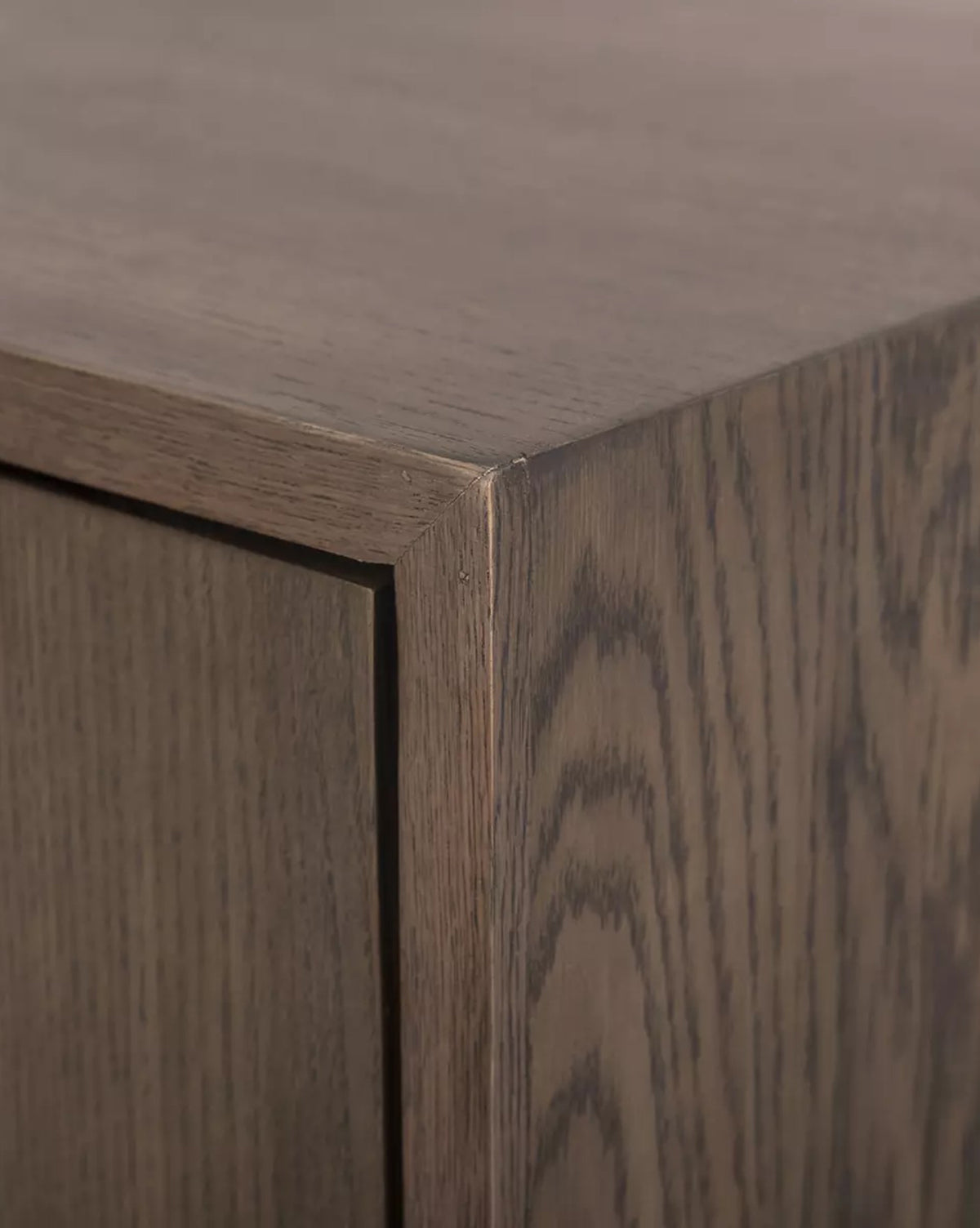 Close-up of the Werner Aged Oak Sideboard’s corner, showcasing its natural brown finish and the highlighted wood grain and texture for a modern, elegant look, by McGee & Co.