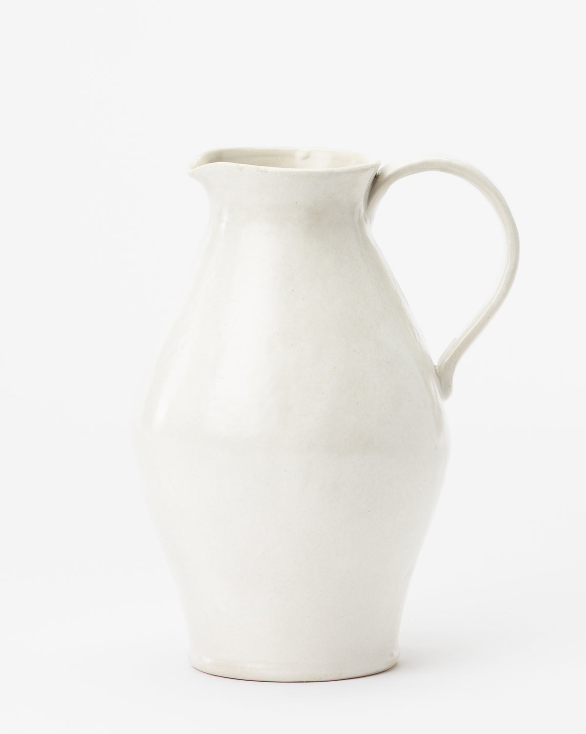 The White Ceramic Pitcher features a curved body, wide spout, and single handle with a smooth matte finish, set against a plain white background, by McGee & Co.