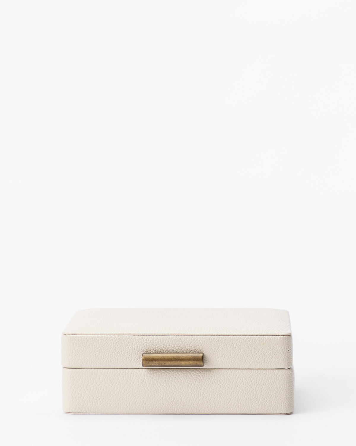The Cream Shagreen Box is a small, closed, rectangular box with a textured surface and brass-colored handle, shown against a plain white background.