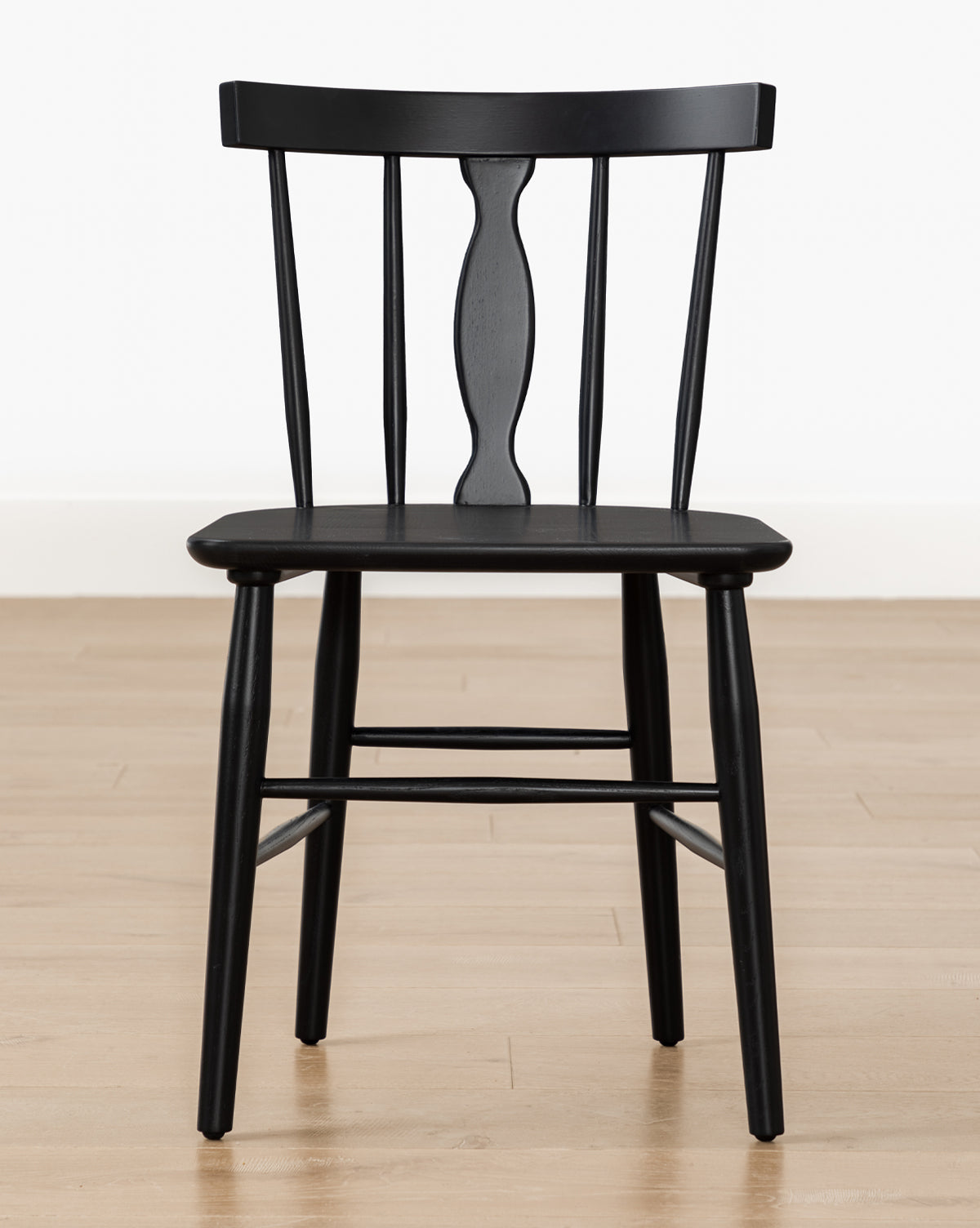 The Whittaker Chair, with its solid oak build, curved backrest, and three vertical slats, adds an elegant touch to any dining area, by McGee & Co.