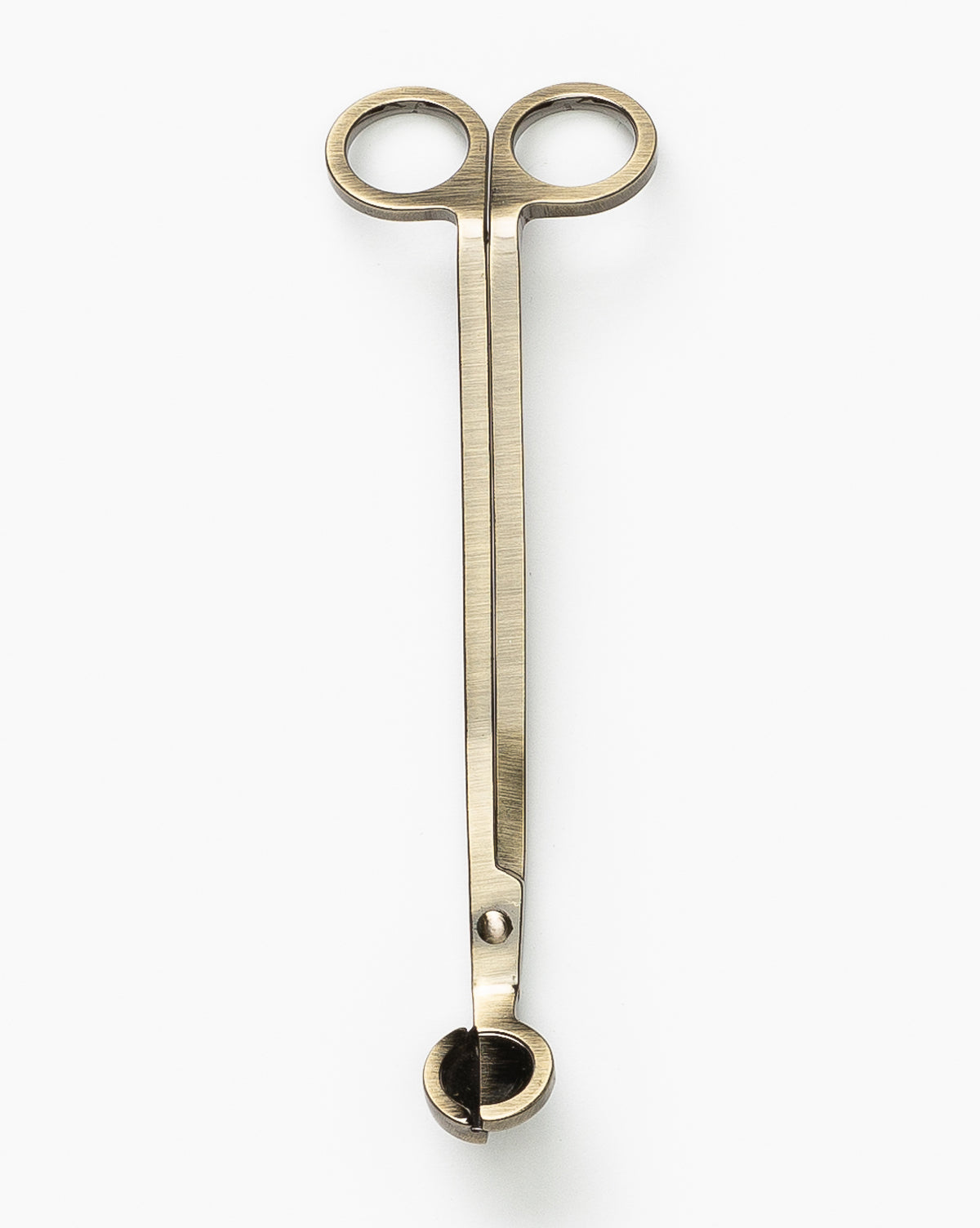 The Wick Trimmer features brass, scissor-style handles and a small cutting box for precise candle wick maintenance, helping candles last longer. Shown against a white background.