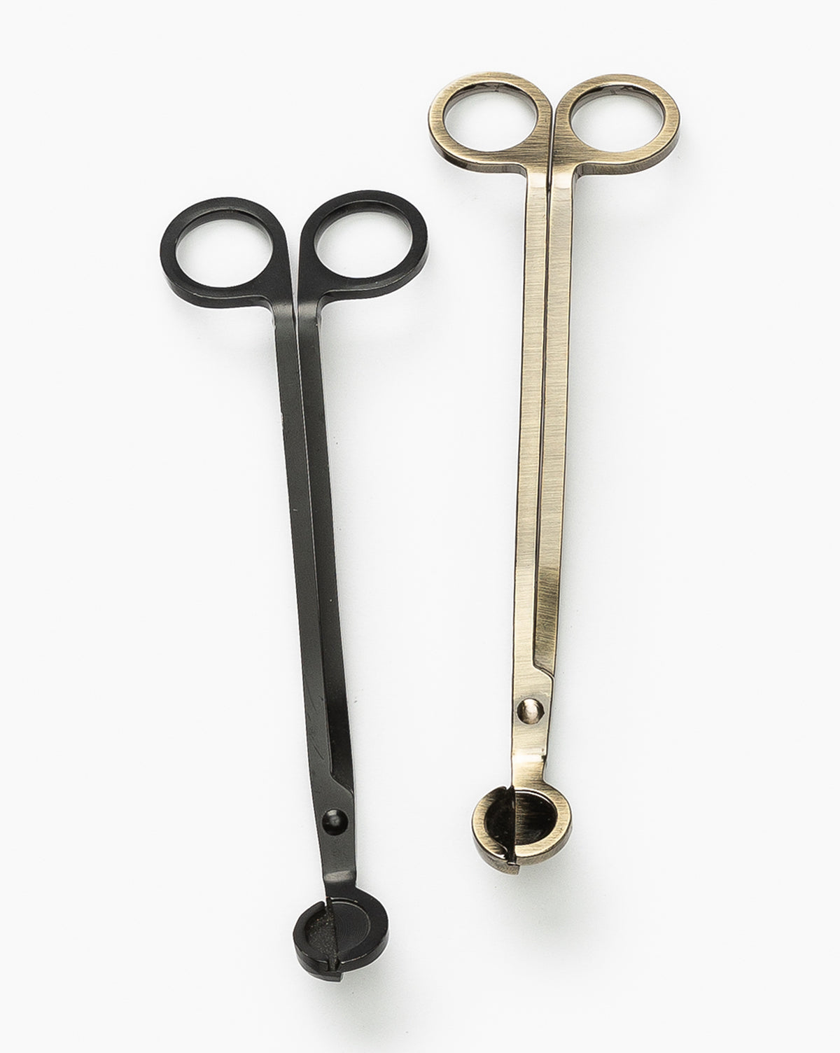 Two Wick Trimmers, one black and one gold, with scissor-style handles and flat circular cutting ends, are displayed side by side on a white background—ideal tools for wick maintenance and longer candle life.