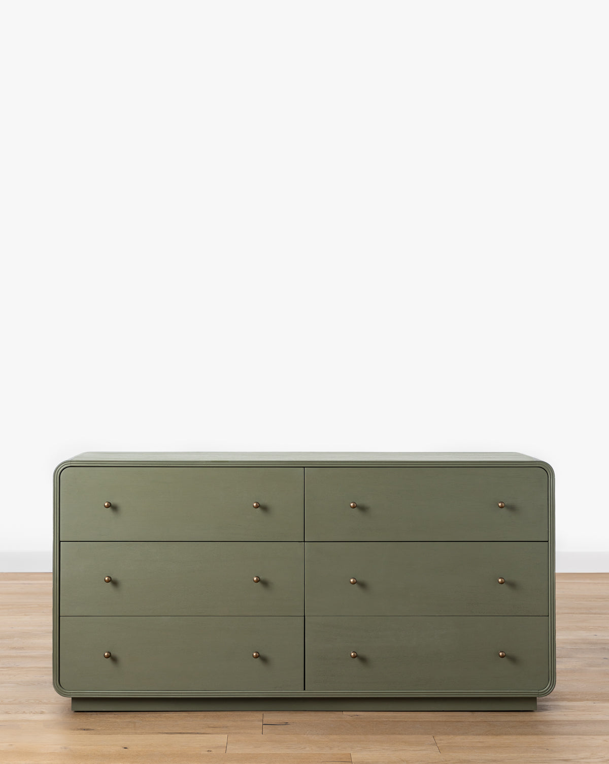The Wilkins Laurel Dresser, in modern laurel green, features six soft-close drawers with small round knobs—ideal for enhancing your bedroom décor, by McGee & Co.