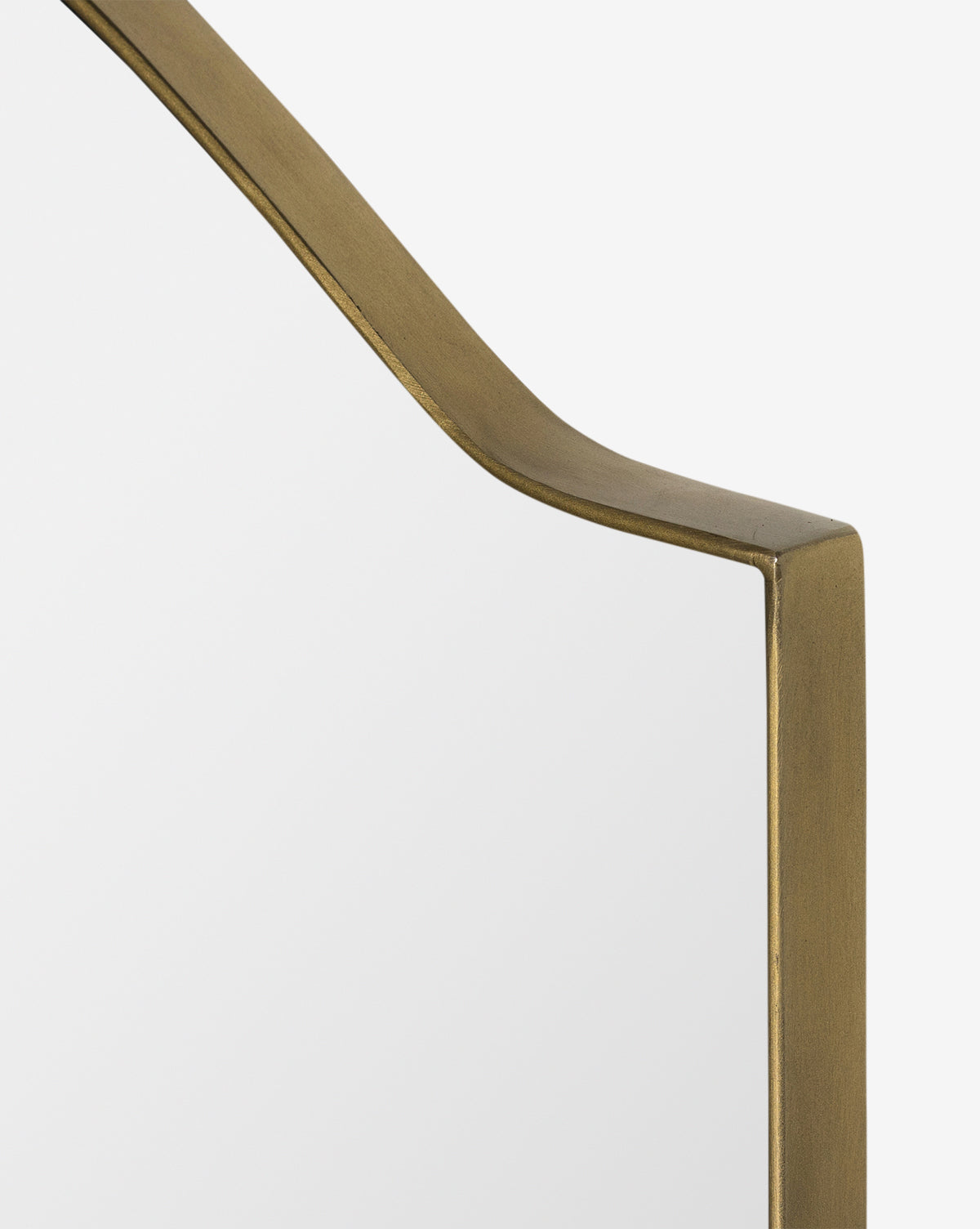 Close-up of the Willson Wall Mirror, a square mirror with a gold iron frame and one curved, angled top corner, set against a plain white background, by McGee & Co.