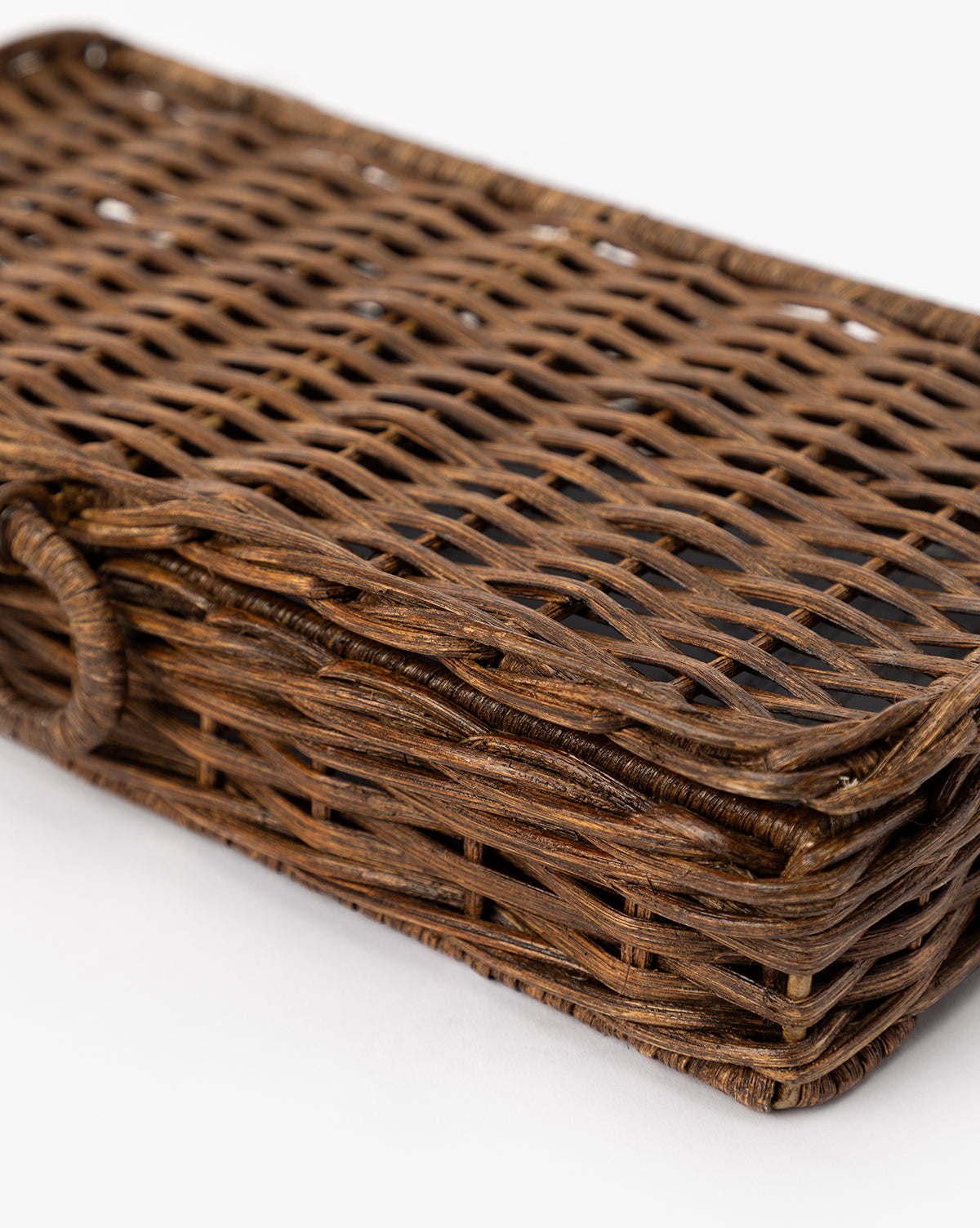 A close-up of the Windmere Woven Box, a rectangular brown wicker container with a woven pattern and rounded edges, displayed on a white background by McGee & Co.