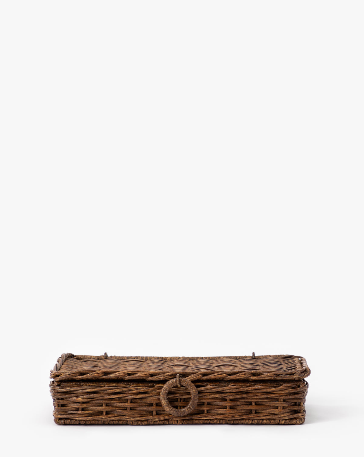 The Windmere Woven Box, a rectangular brown wicker container with a lid and circular handle, is set against a plain white background by McGee & Co.