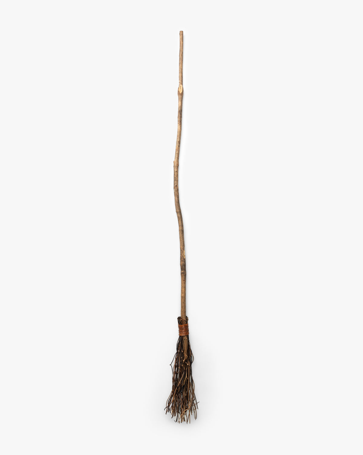 The Creative Co-op Witches Broom features a long, uneven wooden handle and twig bundle, making it ideal as handcrafted Halloween decor. Shown against a plain white background. McGee & Co.
