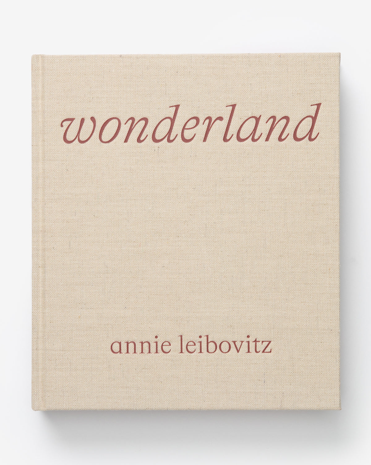 A beige hardcover book titled Wonderland in lowercase rose-colored font, with annie leibovitz beneath in smaller lowercase text—an ideal pick for fans of fashion photography.