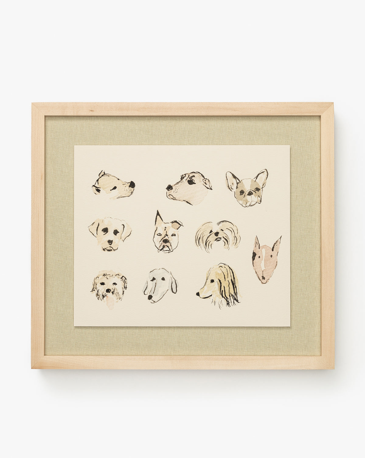 Woof is a fine art print of twelve unique, hand-drawn dog heads on a beige background in a sleek maple wood frame—perfect for adding charm to children’s room decor, by McGee & Co.