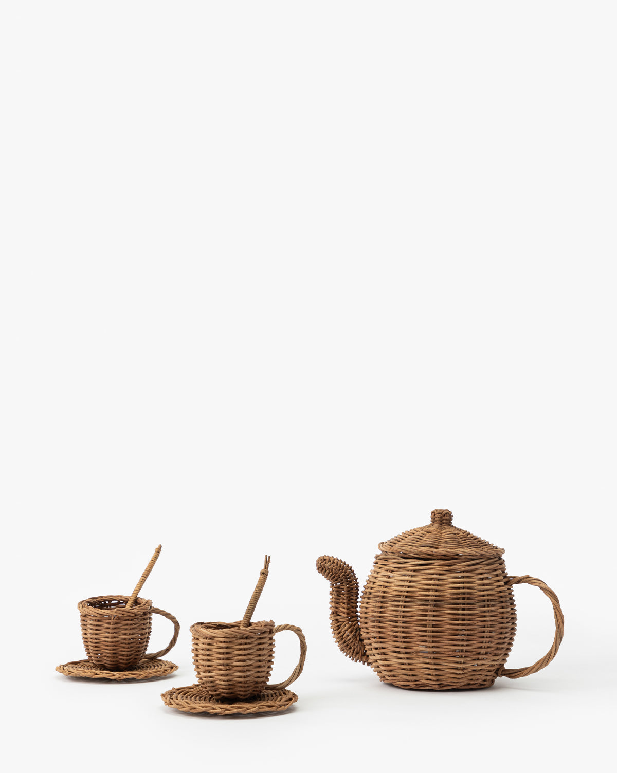 The Woven Rattan Play Tea Set (Set of 7) includes a teapot, two teacups with saucers, and spoons—perfect for imaginative play, by McGee & Co. All pieces are displayed on a white background.