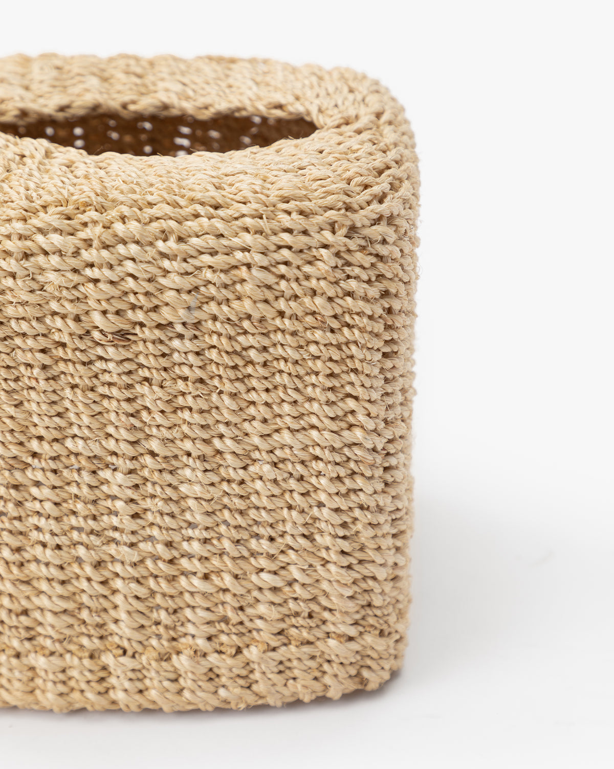 Close-up of the corner of a square Woven Tissue Box Cover made from abaca fiber, showing its detailed texture and weave—ideal for adding style to your bathroom decor.