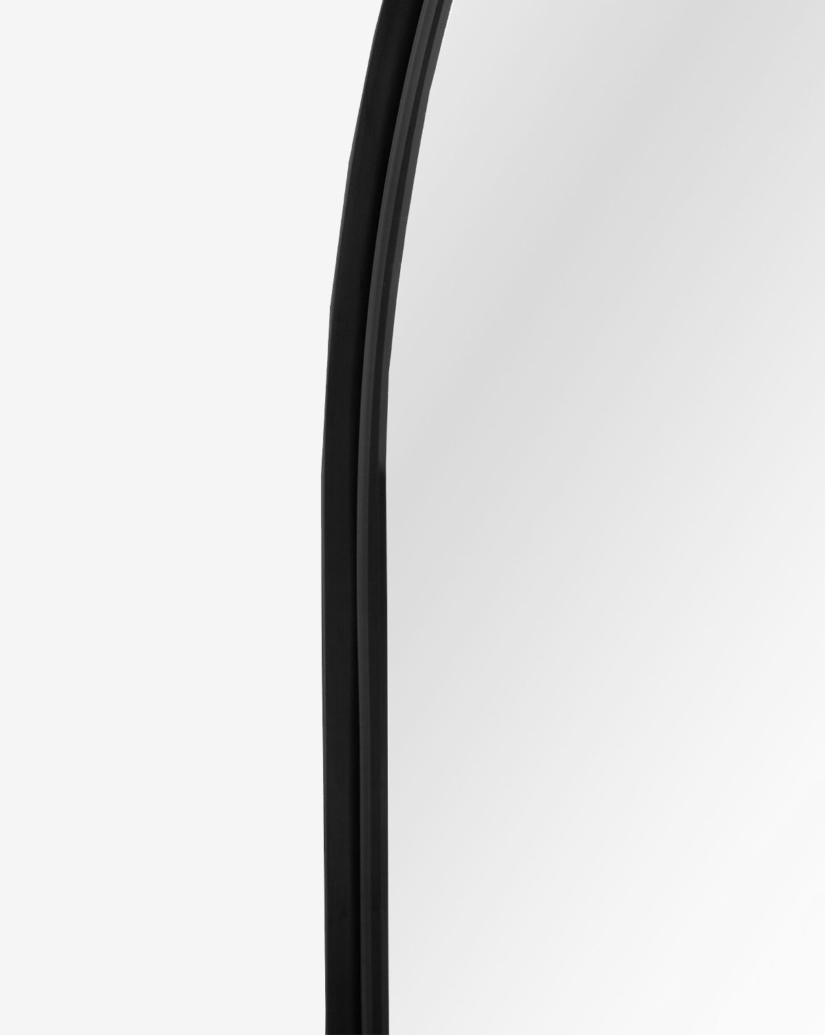 Close-up of the Wylie Arched Mirror’s black-framed upper edge with shatterproof glass, set against a plain white background by McGee & Co.