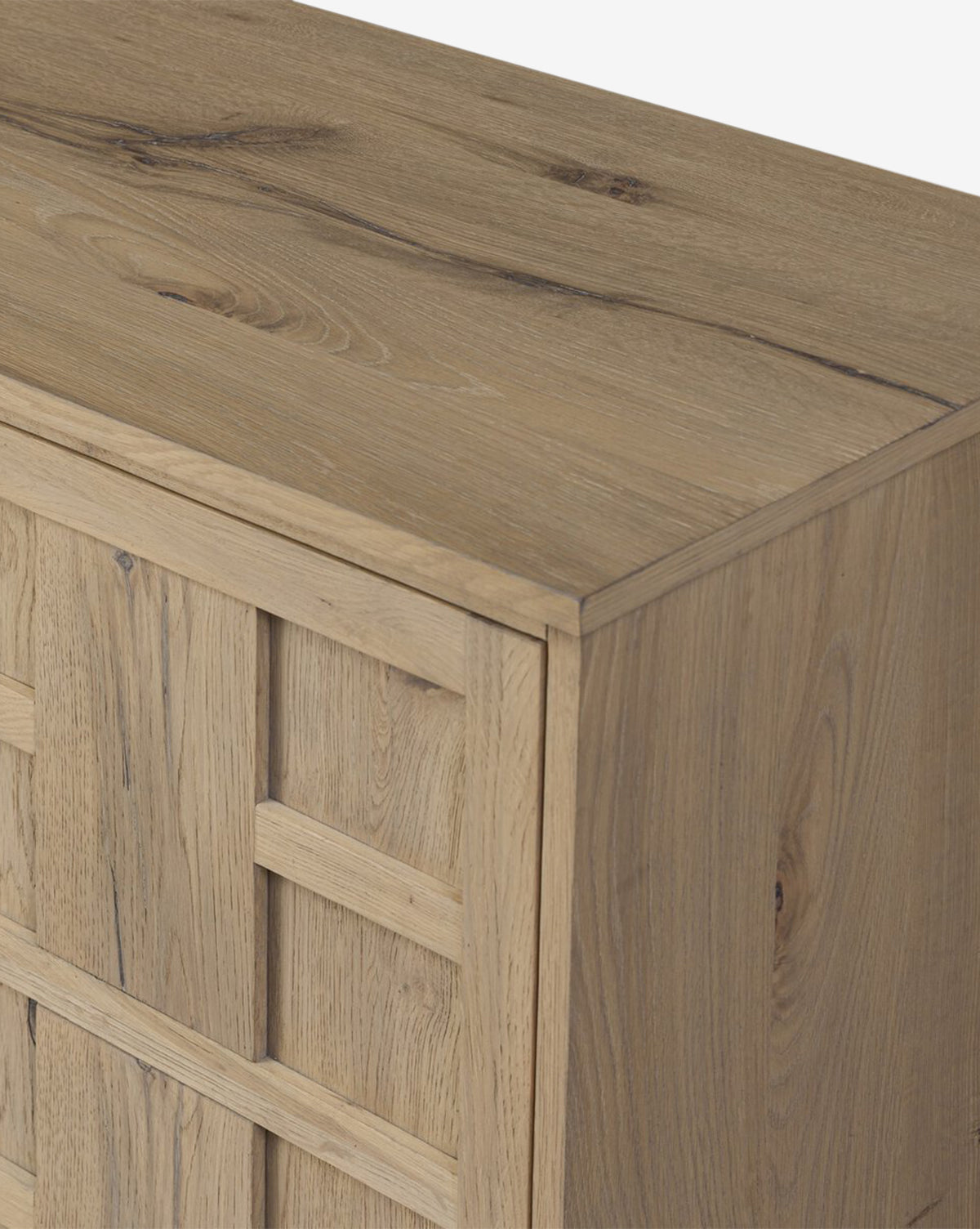 A close-up of the Wynne Sideboard shows its smooth top and woven-style side panel, emphasizing the elegant natural wood grain and texture of this solid oak sideboard, by McGee & Co.